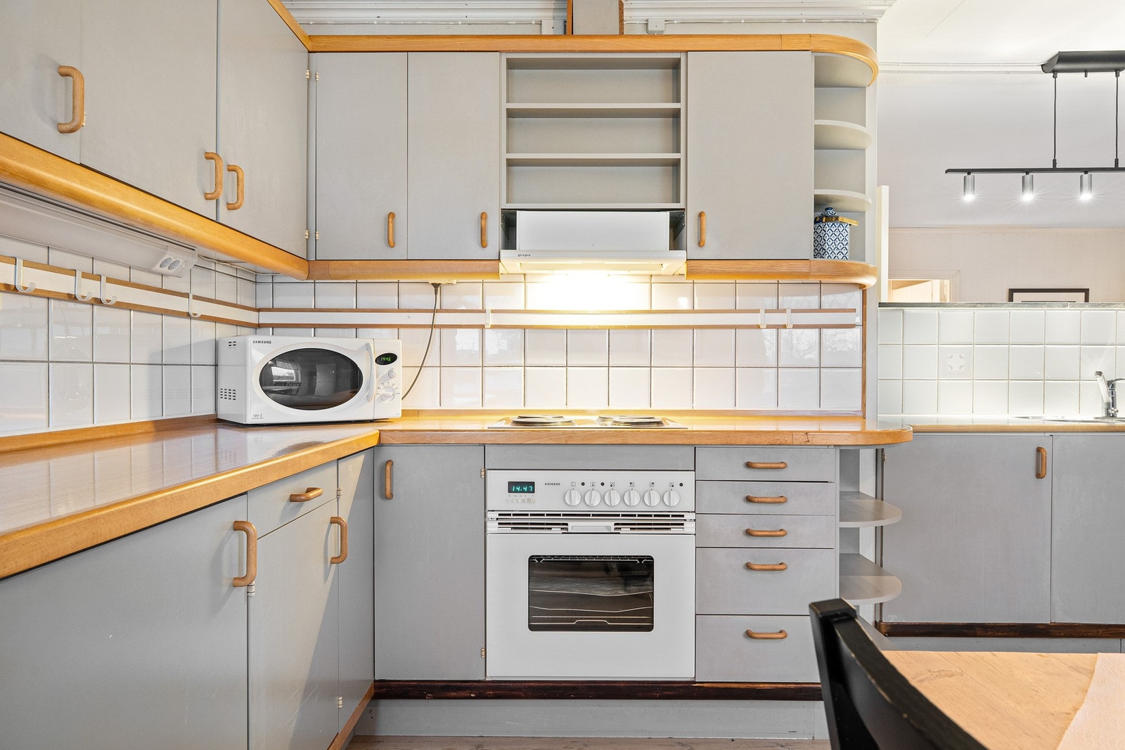 Romslig kjøkkeninnredning med integrert stekeovn og platetopp. Frittstående kjøleskap (medfølger ikke). Galleribilde