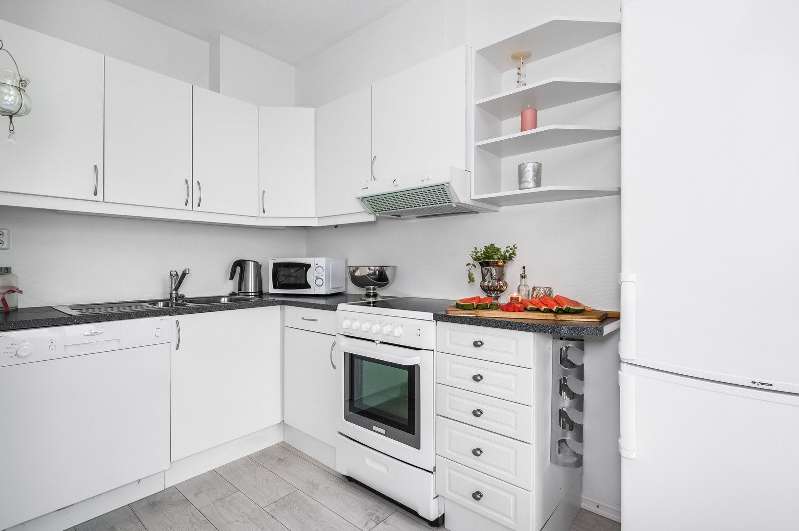 Kjøkken med komfyr, kombiskap og oppvaskmaskin. Galleribilde