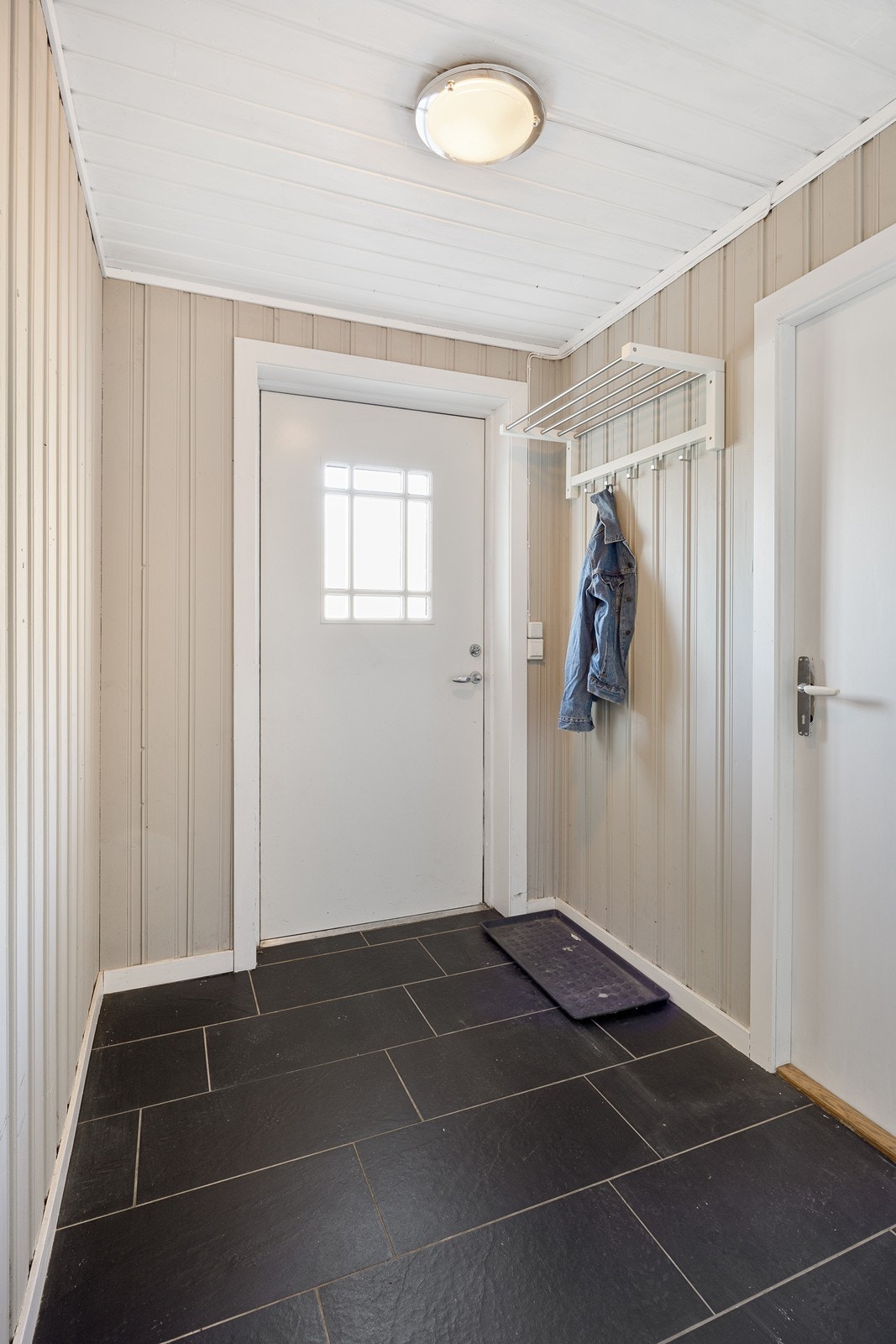 Fra gangen i underetasjen er det ytterdør ut til nordsiden av boligen. Galleribilde