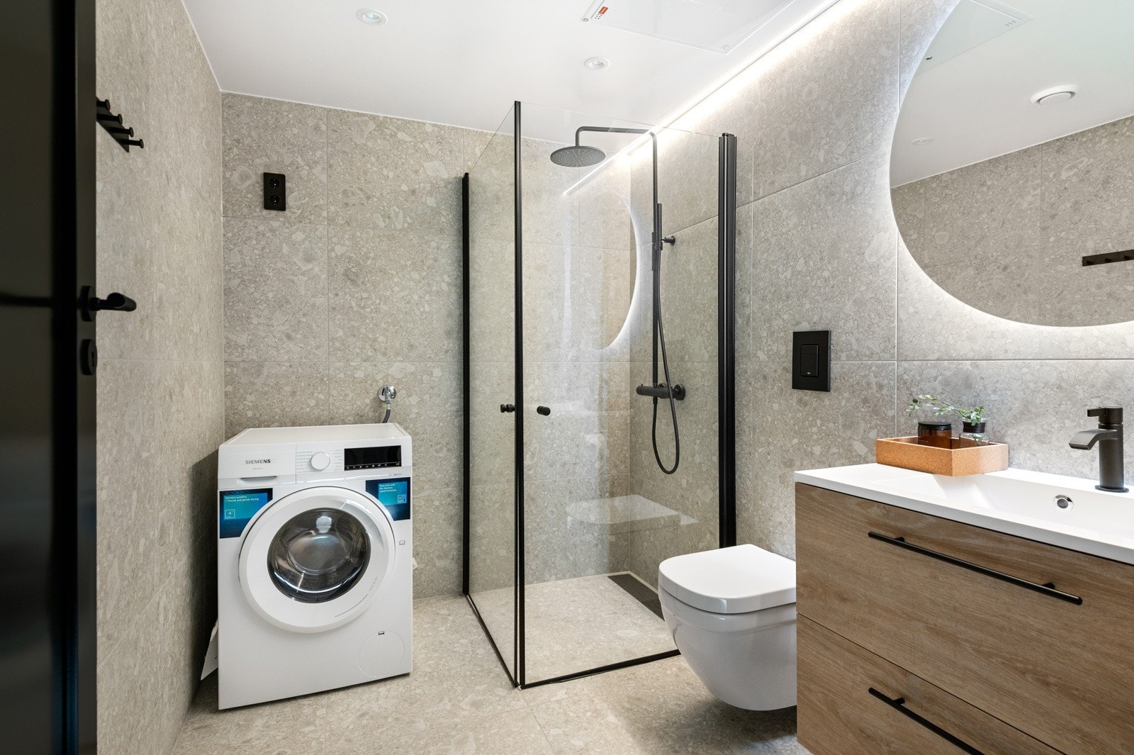 Delikat baderom med tidsriktige fliser og opplegg for vaskemaskin Galleribilde