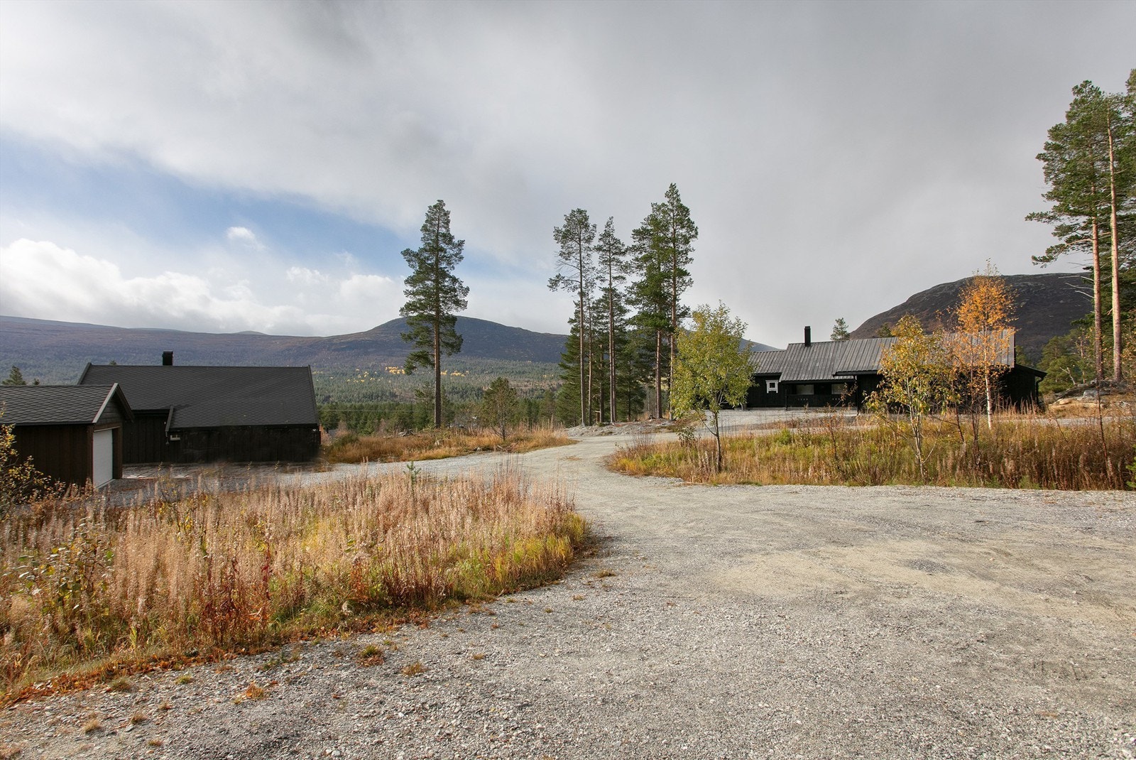 Stor gruslagt gårdsplass med gode parkeringsmuligheter Galleribilde