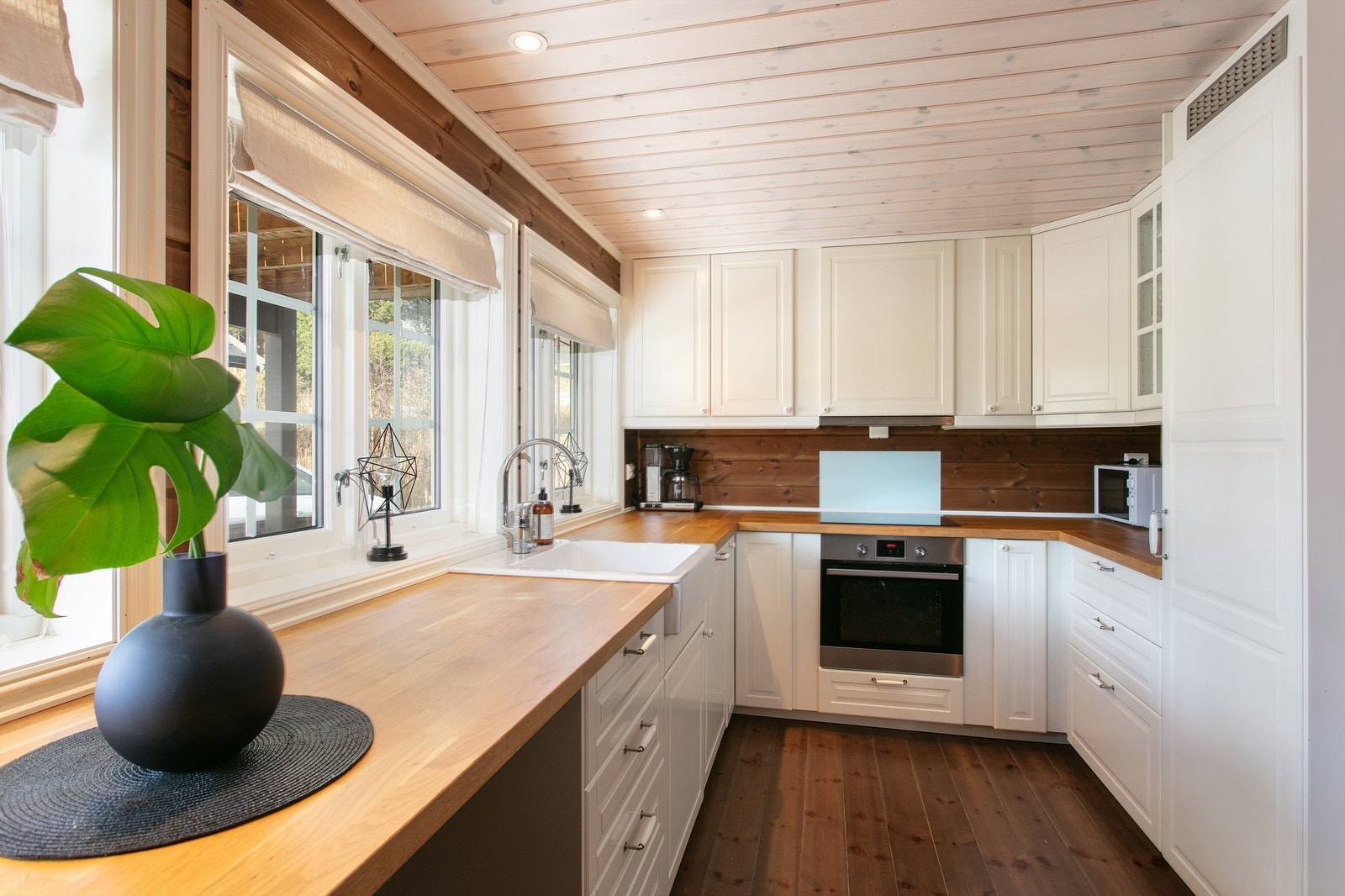 Kjøkkeninnredning med hvite profilere fronter og heltre benkeplate Galleribilde