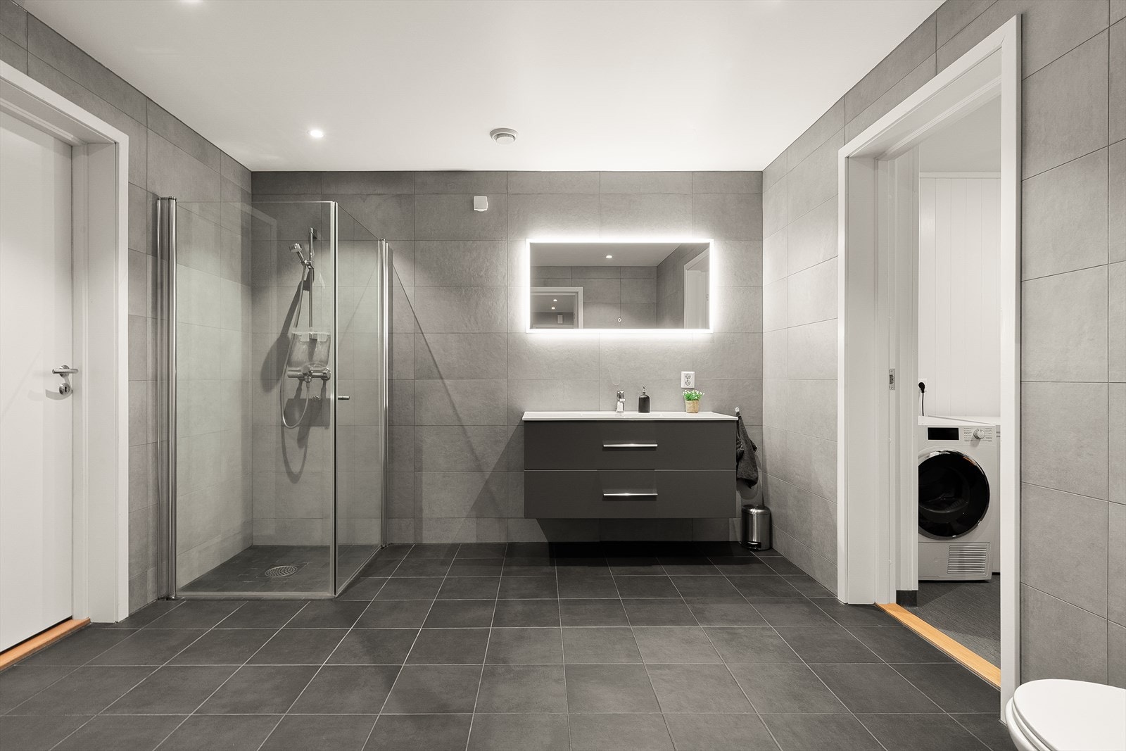 Underetasjen har et meget romslig baderom i et tidløst design med varmekabler i gulv, downlights i himling og lekkert inventar. Galleribilde