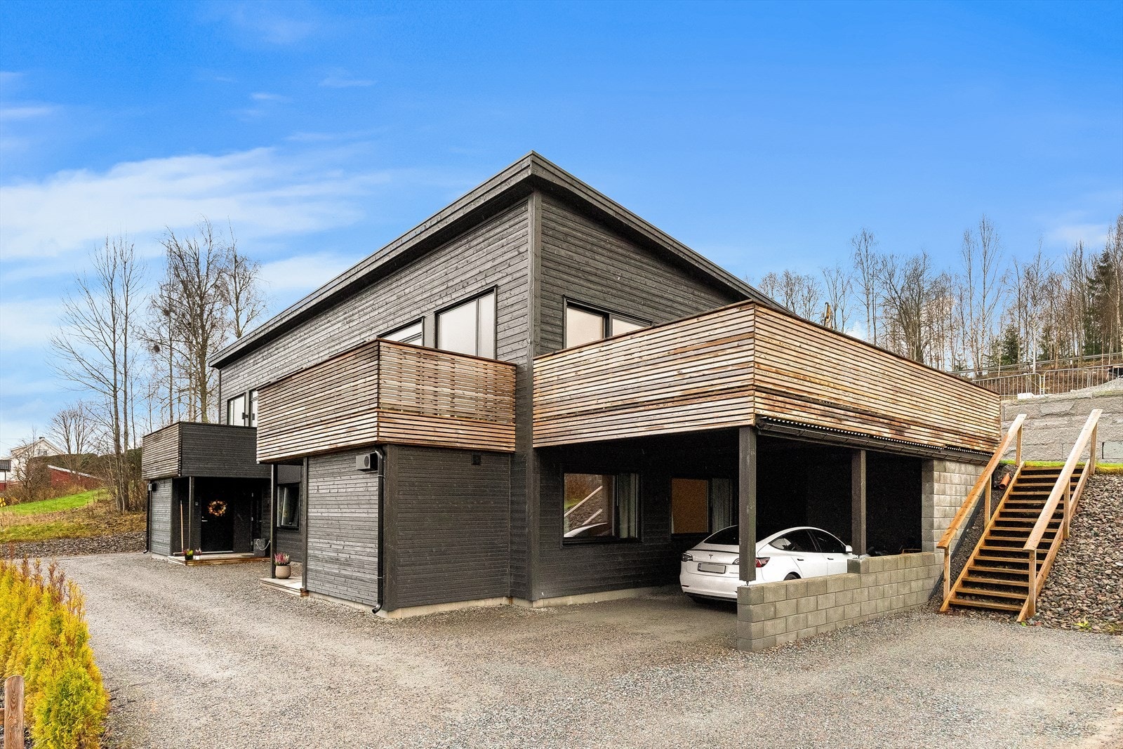 Boligen har stor carport med plass til to biler og utstyr. Det er montert el-billader og dobbelstikkontakt på vegg i carport. Galleribilde