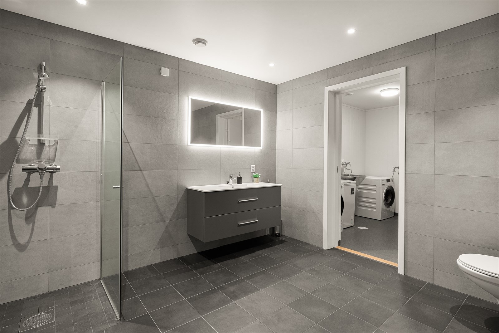 Fra baderommet i underetasjen har man tilgang til praktisk vaskerom og innendørs bod/teknisk rom. Galleribilde