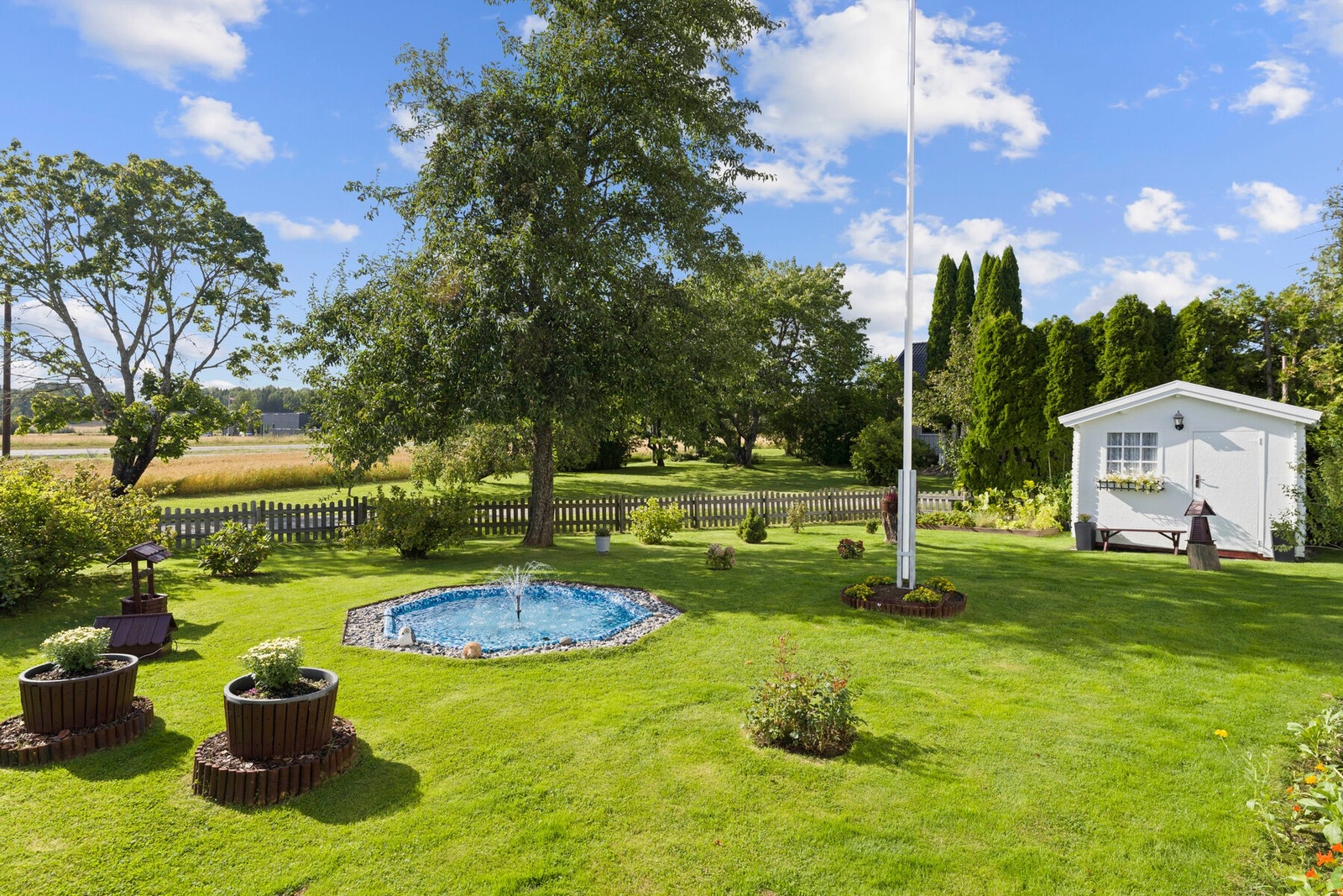 Frukttrær, bærbusker, fontene og flotte grønne soner som skaper en følelse av landlig ro og naturlig skjønnhet. Galleribilde