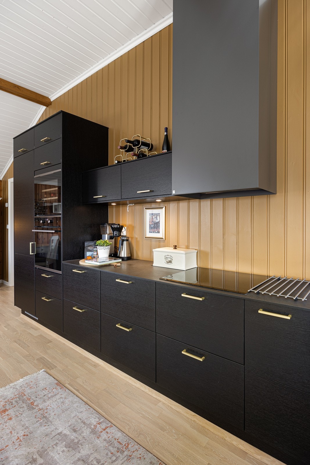 Videre er kjøkkenet utstyrt med integrerte hvitevarer som oppvaskmaskin, vinskap, kjøleskap, stekeovn og induksjonstopp, samt ventilator, benkestikk og god arbeidsbelysning. Galleribilde