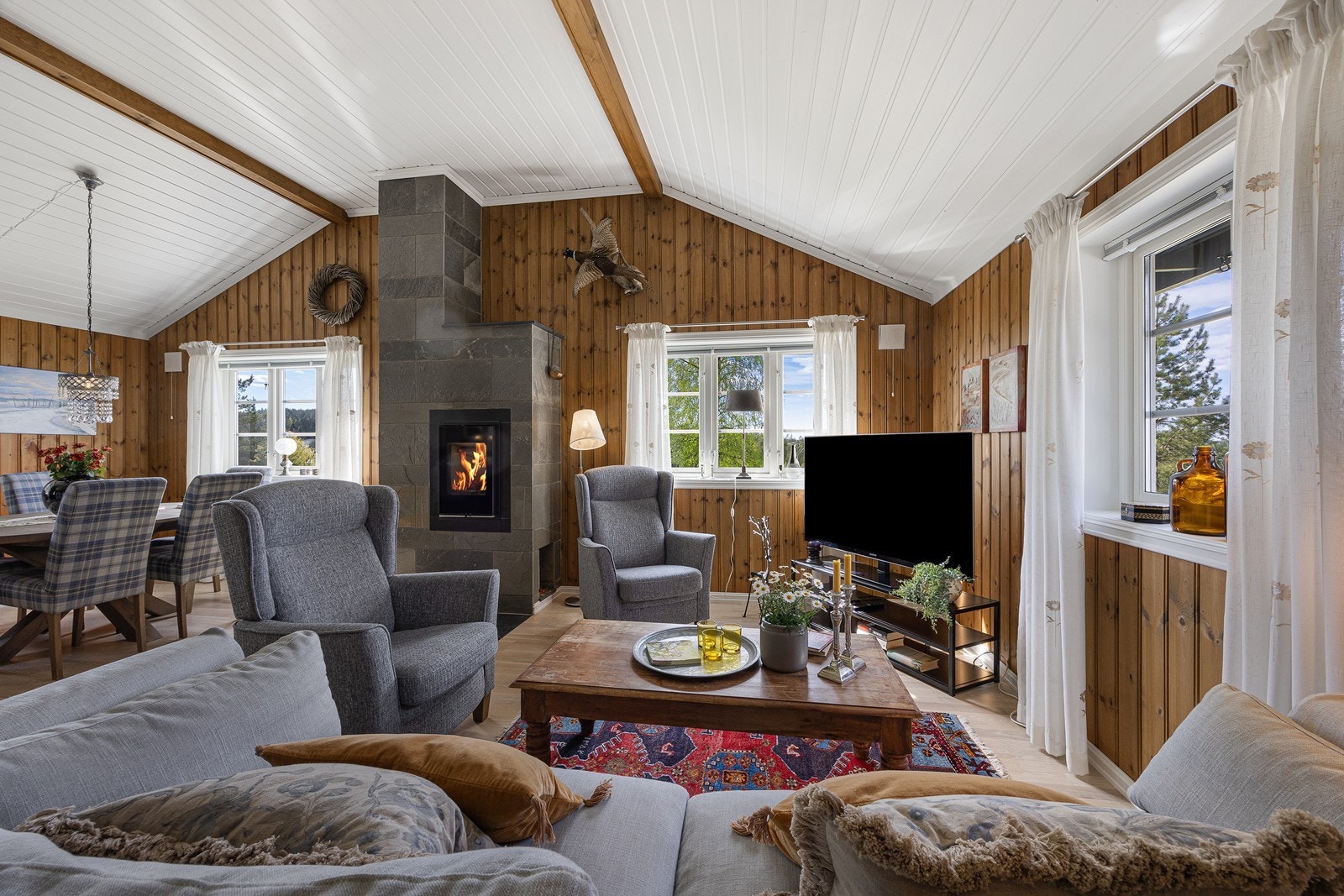 Ekstra varme og hygge på kaldere kvelder sikres med fyr i en moderne, skiferkledd peis med innsats. Galleribilde