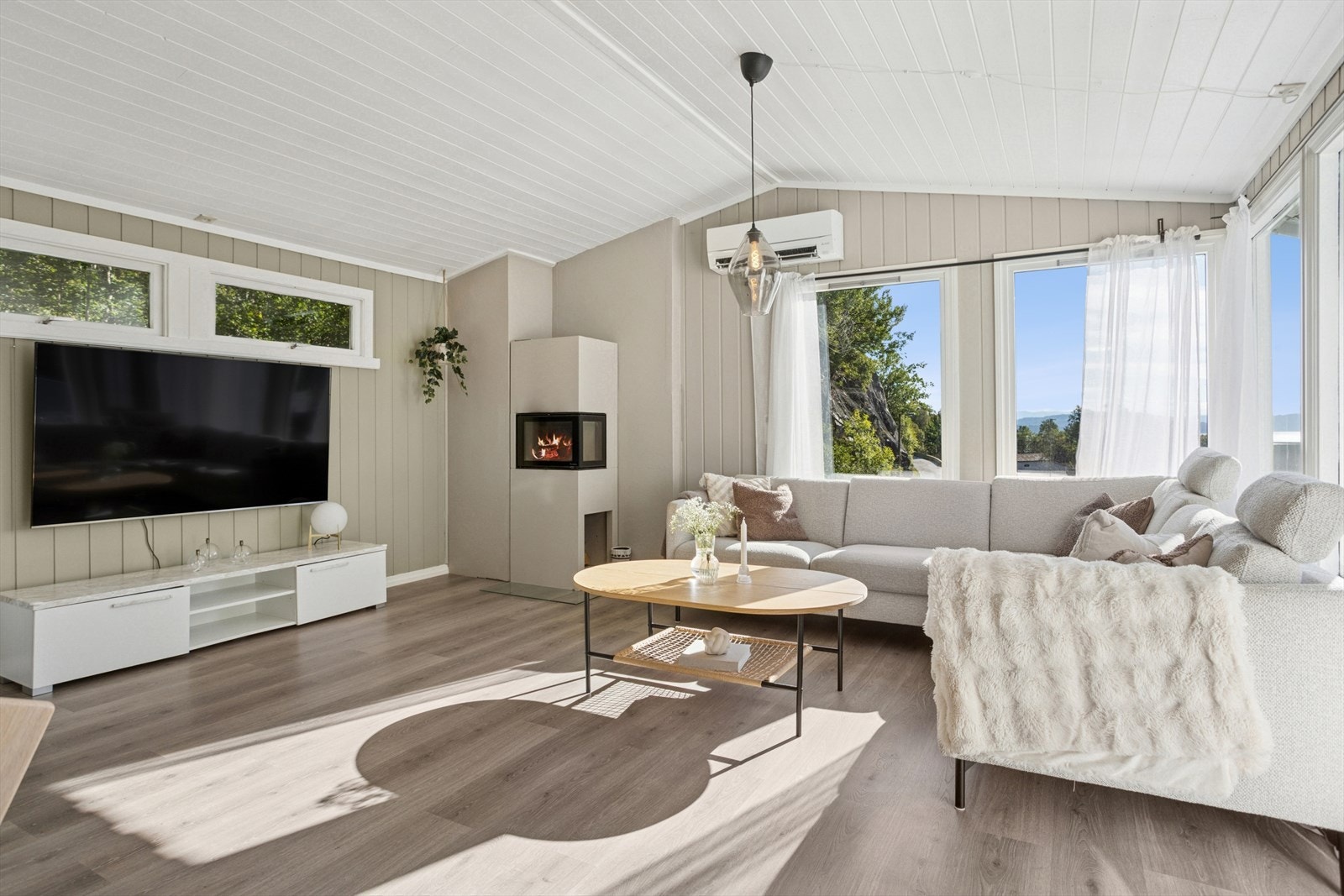 På kjølige dager sørger en stilren peisovn fra Nordpeis (2023) for både varme og hygge, og bidrar til en lun atmosfære i rommet. Du har også en varmepumpe fra 2021. Galleribilde