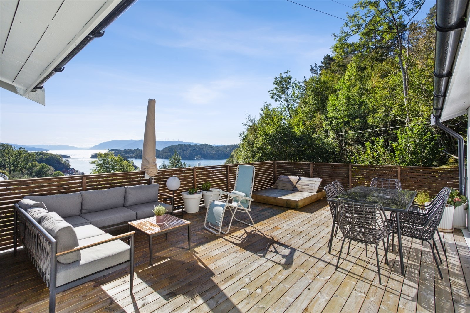 Sørøstvendt terrasse på hele 43 kvm. Her kan du nyte den storslåtte utsikten mot Reksteren, Tysnes og Fitjar - et levende og vakkert landskap som skifter med årstidene. Galleribilde