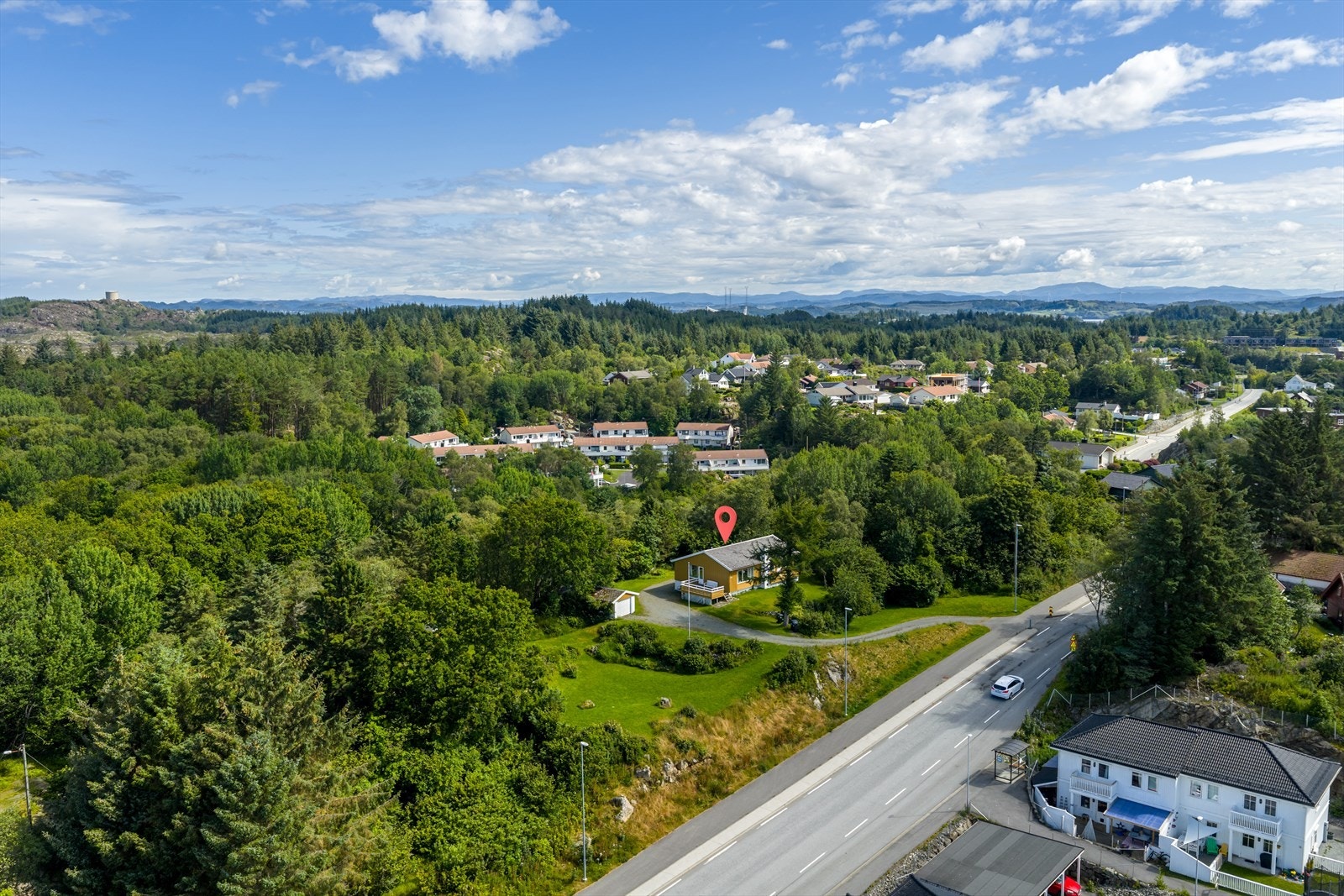 Deler av eiendommen er pent opparbeidet med plen og busker Galleribilde