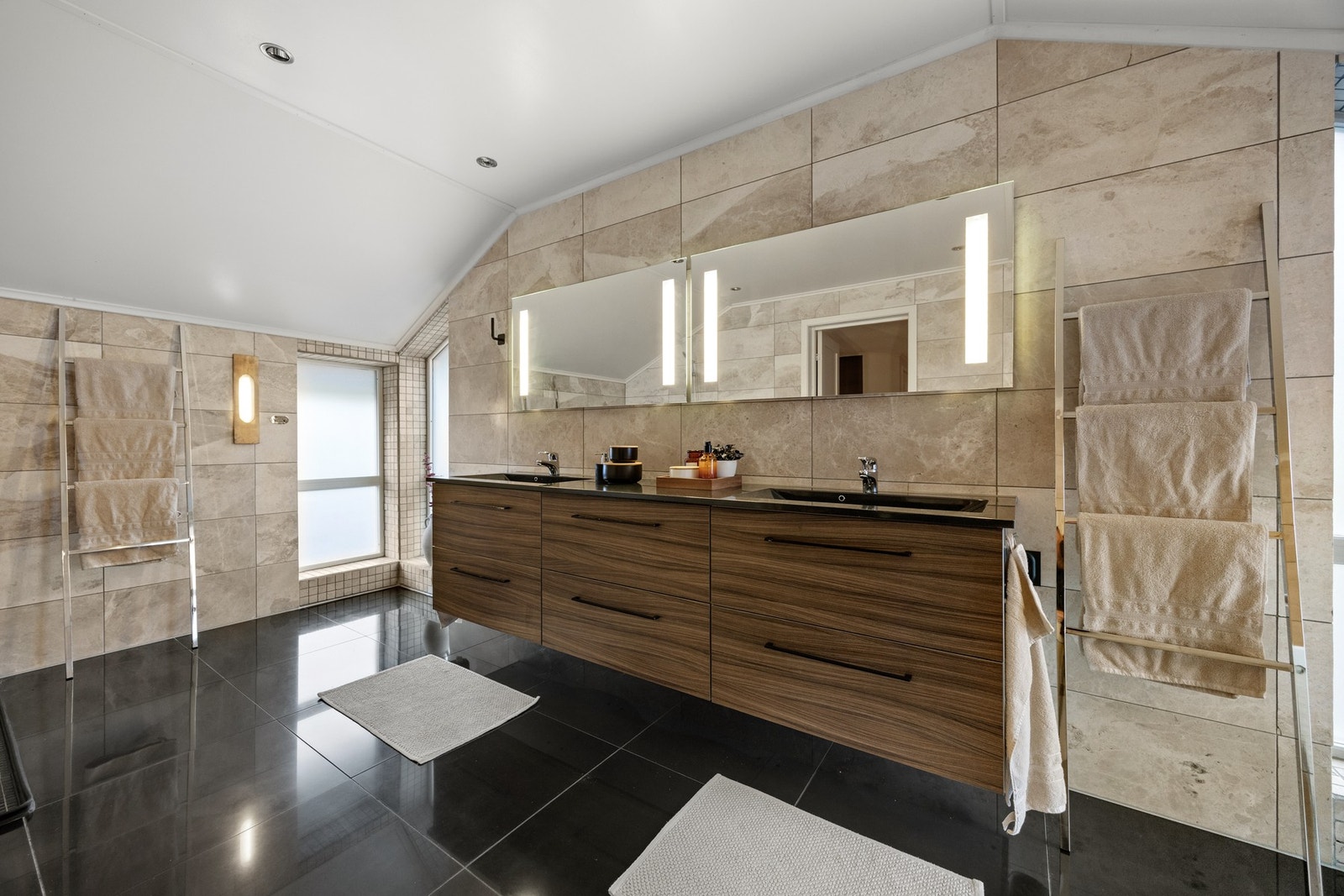 Badet er utstyrt med dobbelt servantskap, toalett, åpen dusj og badekar Galleribilde