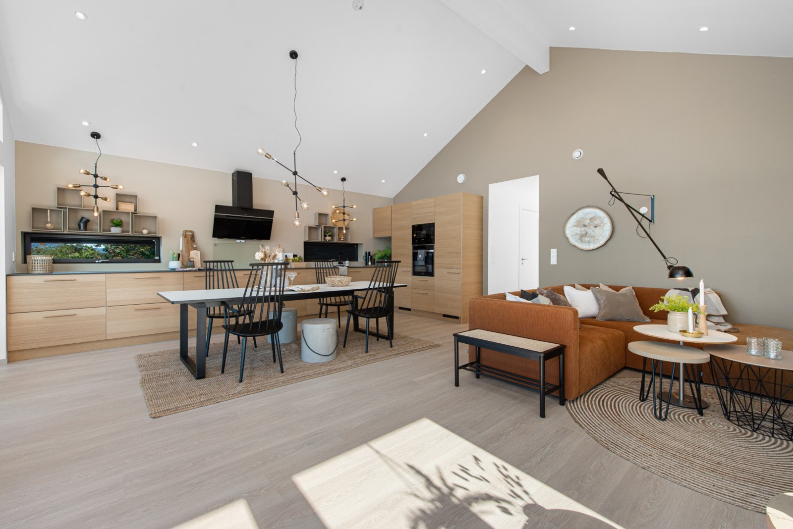 Med en åpen stue/kjøkkenløsning får du en svært god romfølelse og kan innrede med et skikkelig langbord for hele familien Galleribilde