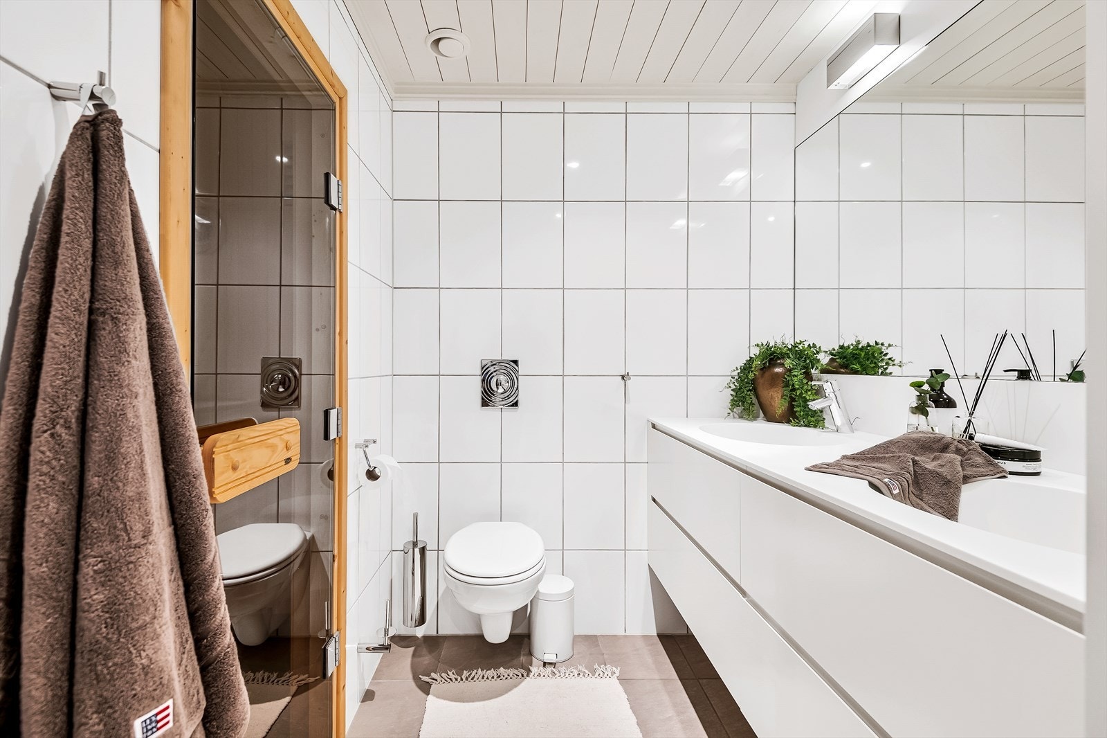 Baderom innredet med heldekkende dobbelt servant, vegghengt toalett og badstue. Galleribilde