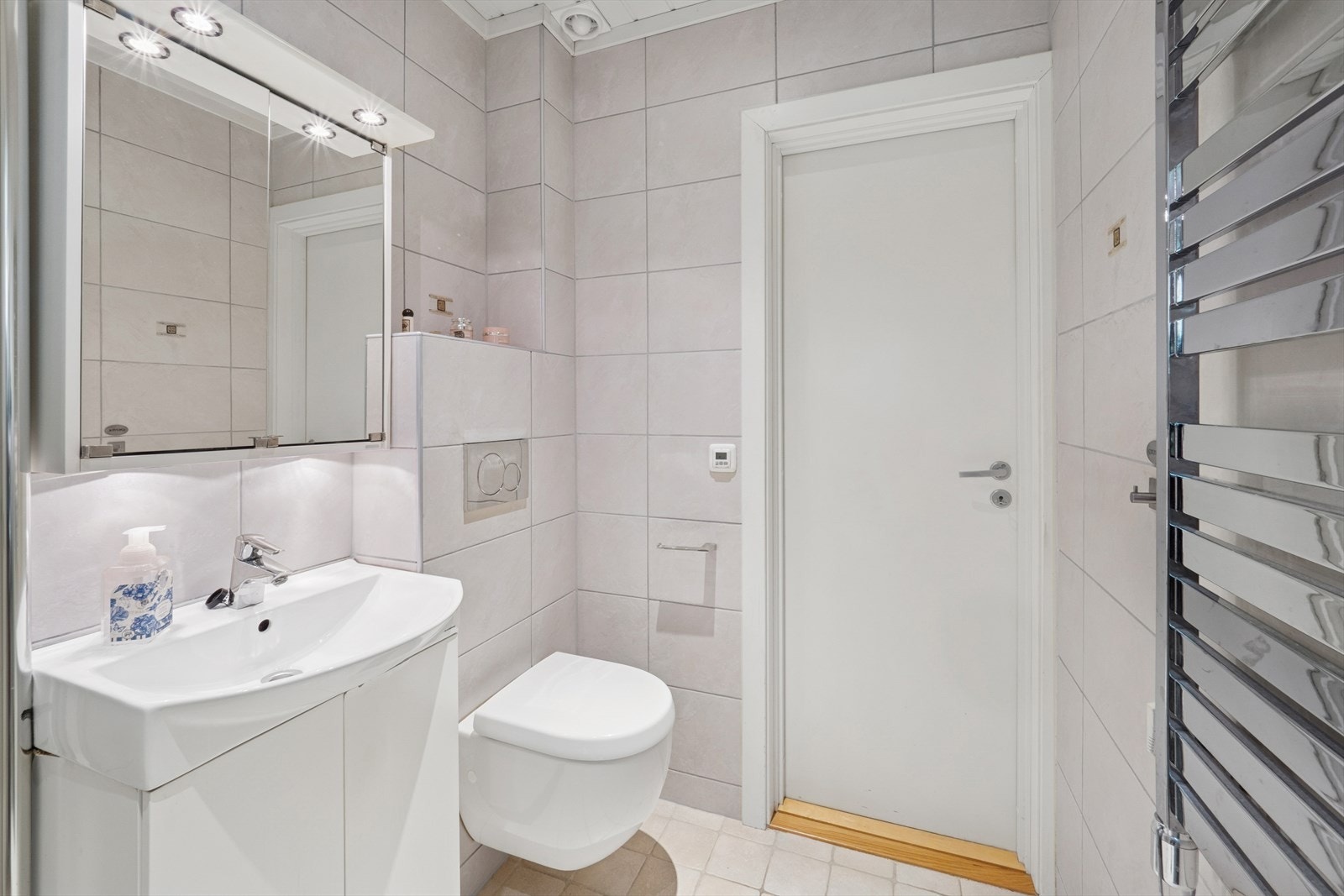 Baderomsinnredningen er pent utført med hvite fronter med underskap, og heldekkende servant. Galleribilde