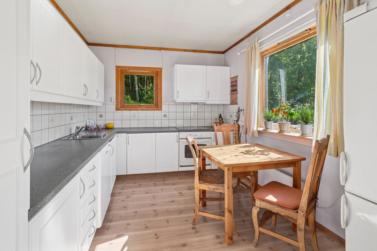 Kjøkkeninnredningen er pent utført med profilerte, hvite fronter som ble byttet i 2012, og laminert benkeplate med nedfelt kjøkkenkum. Galleribilde