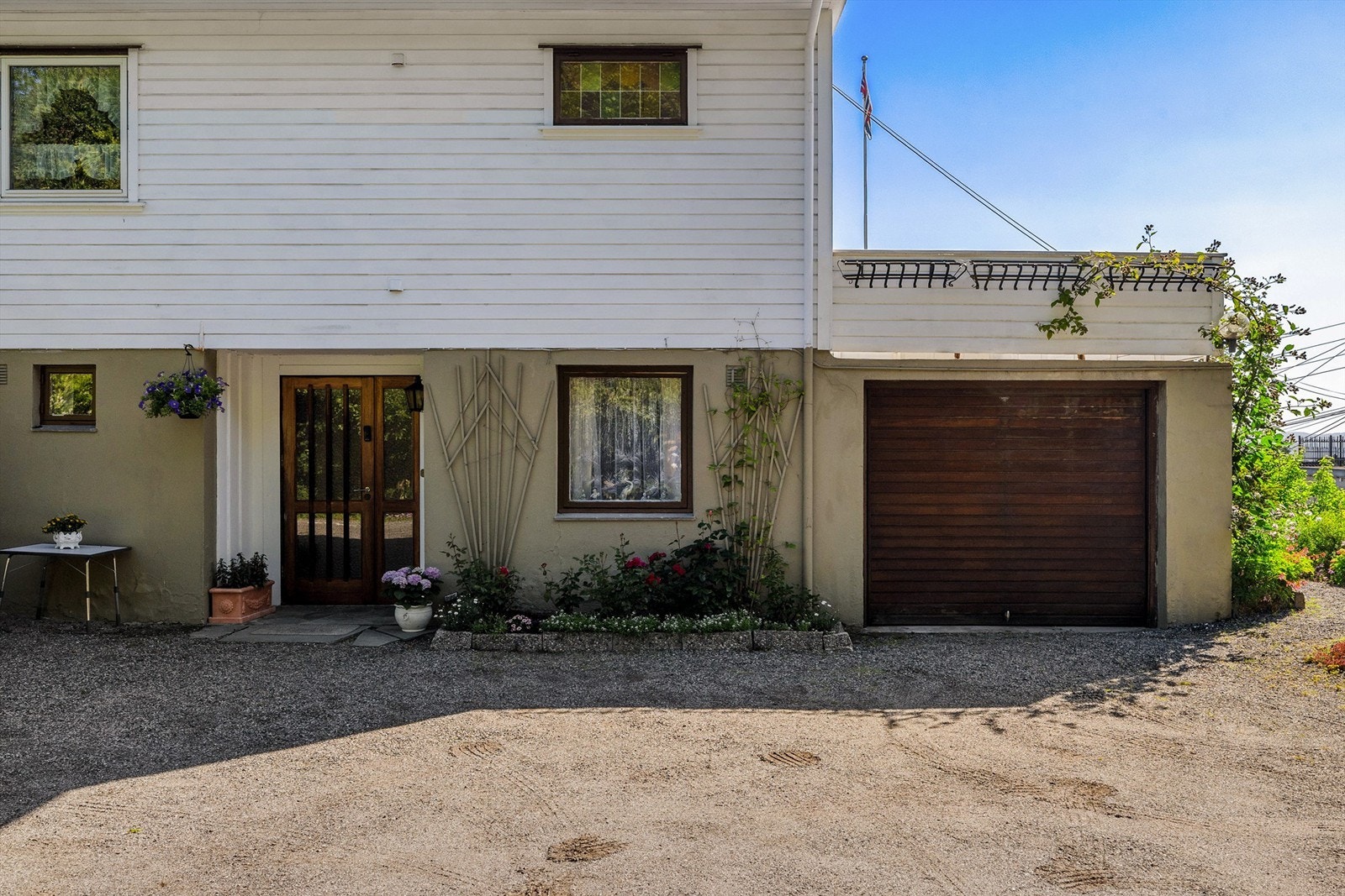 Stor gruset gårdsplass og enkel garasje. Galleribilde