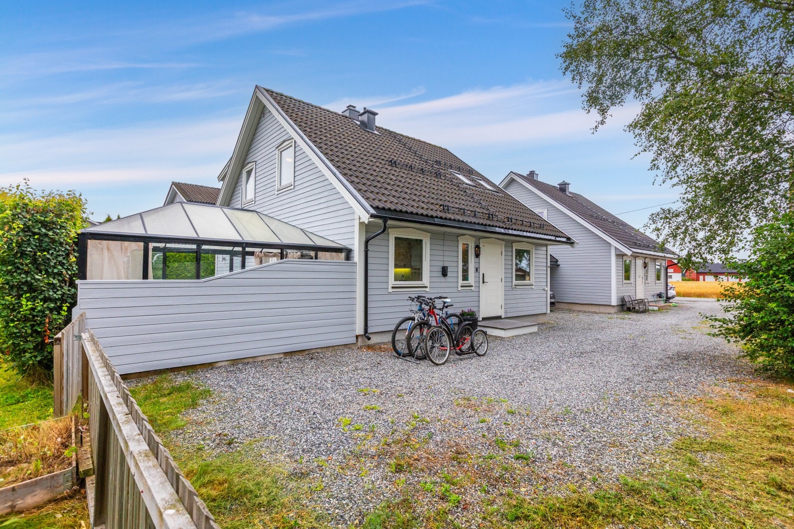 Hver seksjon har egen carport samt biloppstillingsplass til å benytte som sin egen. Plassen lengst inn her mot grinden skal benyttes som gjesteparkering. Galleribilde