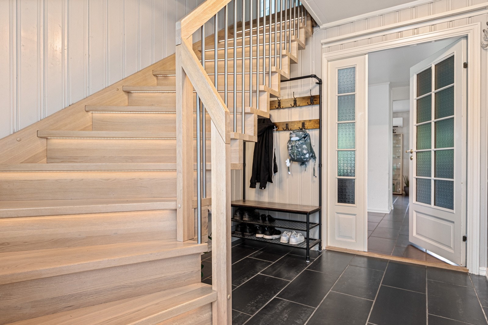 Under trappen er det gode muligheter for en garderobeløsning for ytterklær- og sko. Galleribilde
