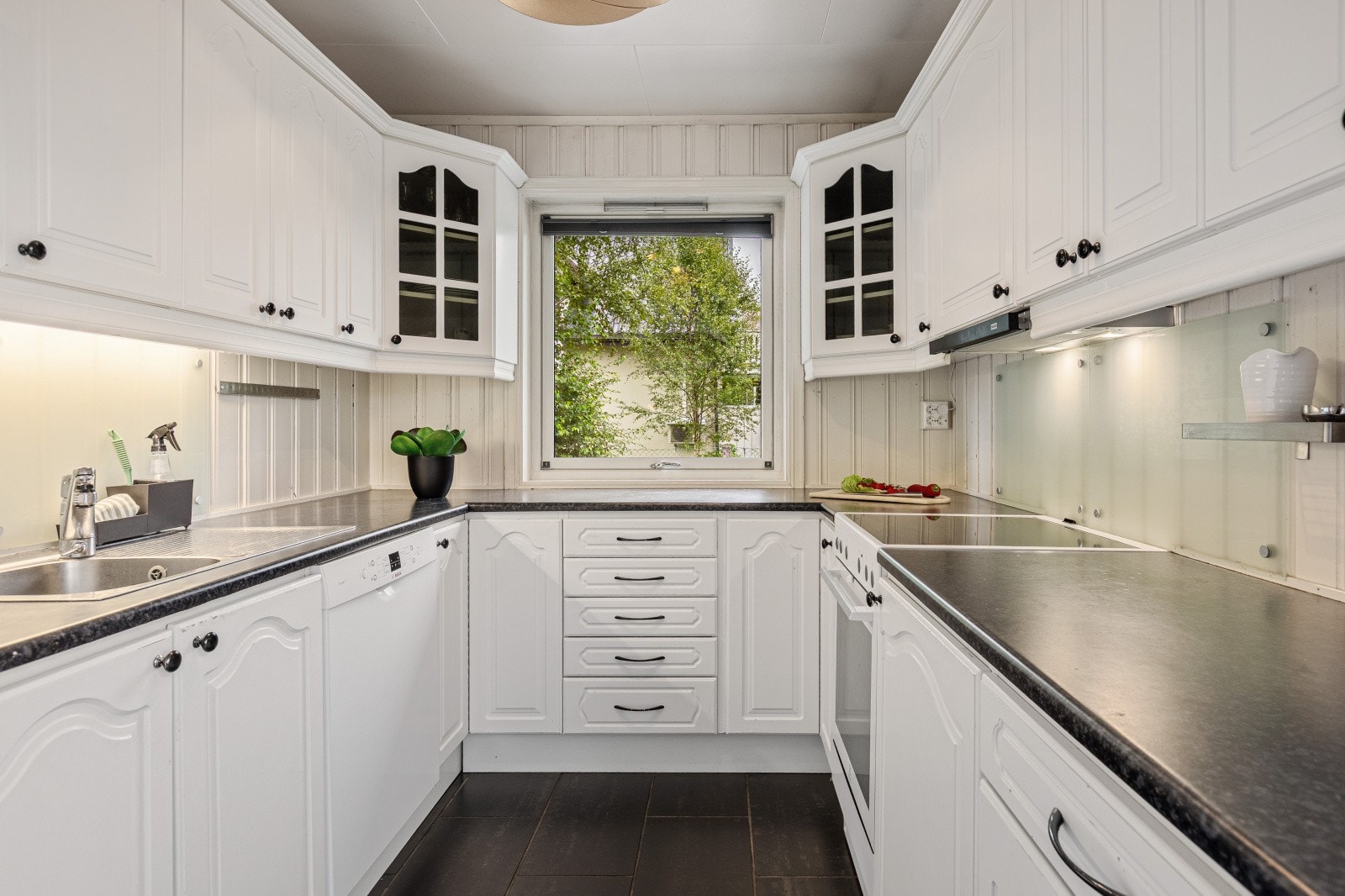 Klassisk kjøkkeninnredning med godt om skap- og benkeplass. Galleribilde