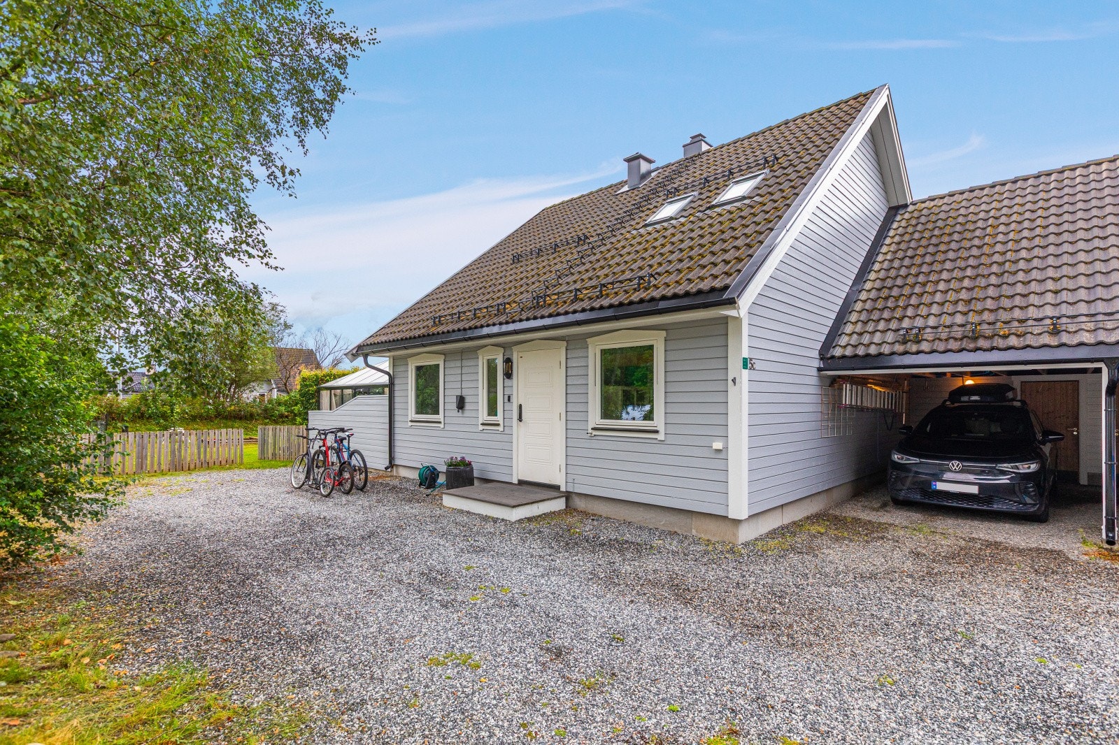 Velkommen! Her bor du i en hyggelig familiebolig med skjermet beliggenhet og parkering i carport. Det er installert elbil-lader på husvegg ved siden av entreen. Galleribilde
