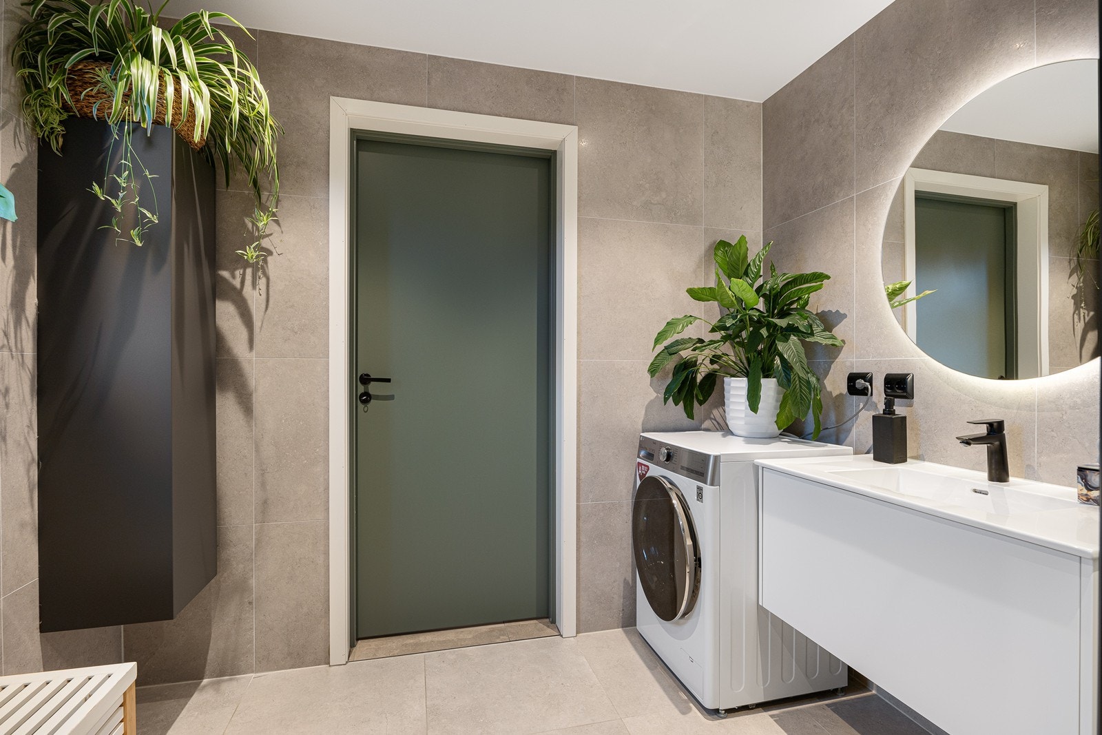 Planløsningen er praktisk, med bad i begge etasjer. Badet nede har god størrelse, lekkert innredet med store vegg- og gulvfliser i ulike gråtoner. Galleribilde