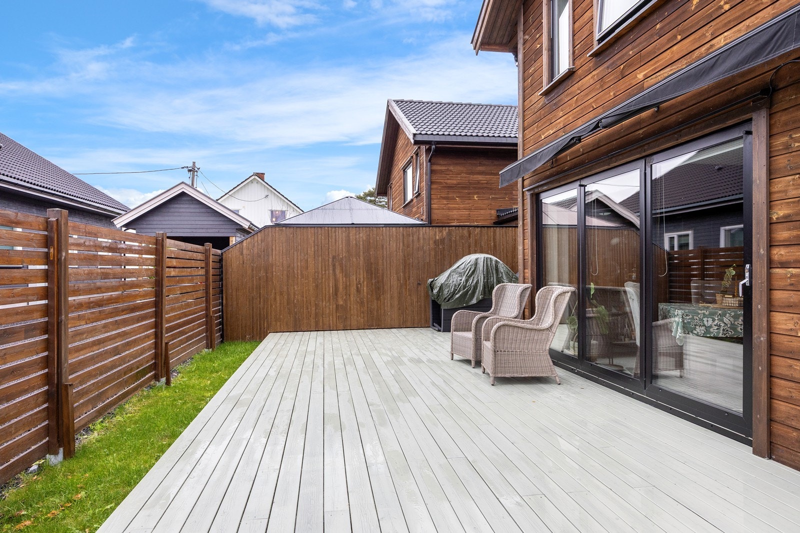 Terrassen har belysning, markise og utetikk for ekstra komfort. Mot naboen er det levegg, og uterommet innbyr til både rolige stunder og store, sosiale sammenkomster. Galleribilde