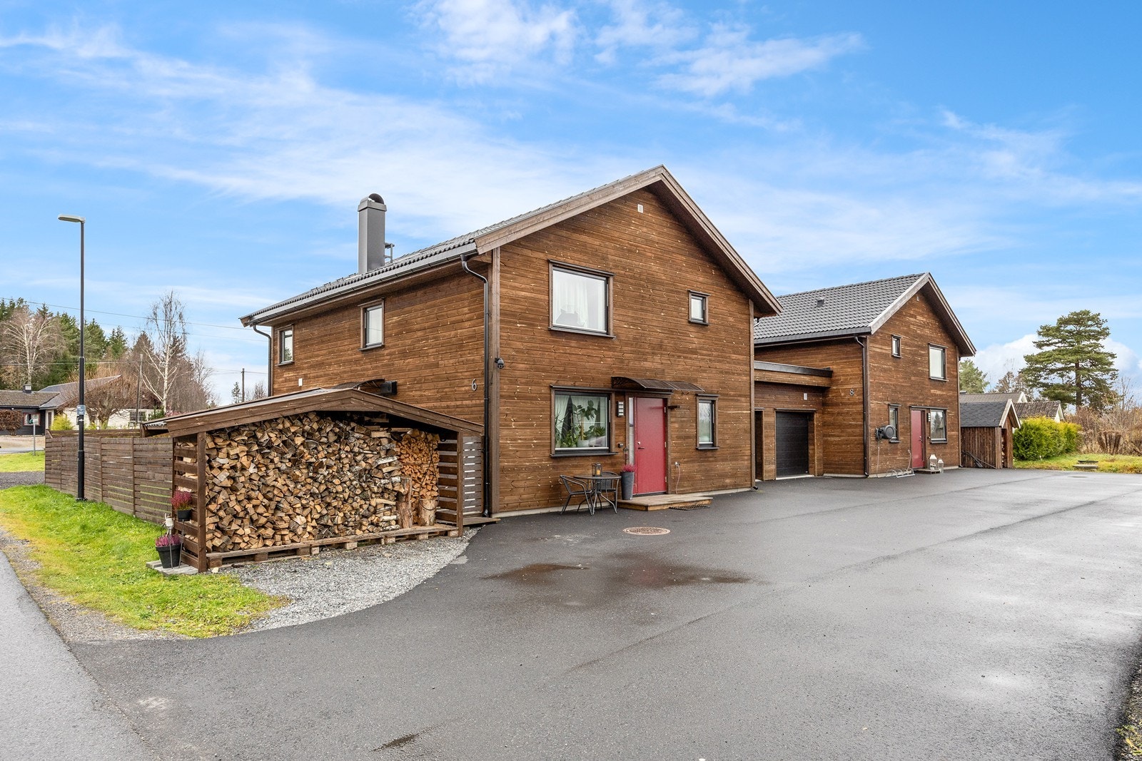 Garasjen er isolert og har elektrisk portåpner. Garasjen binder huset sammen med naboen, og det er etablert trekkerør for elbillader. På inngangssiden finner man også en felles gårdsplass for ytterligere parkering. Galleribilde