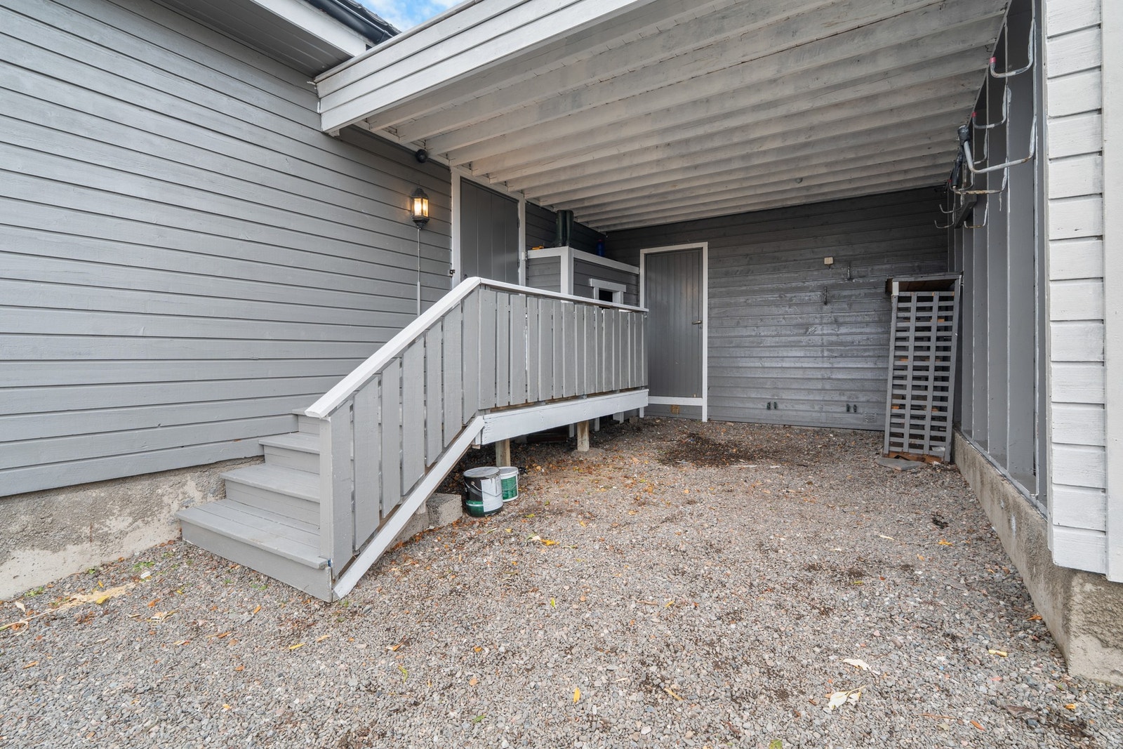 På den gruslagte parkeringsplassen er det også en carport. Herfra kommer man også til boden i bakkant. Galleribilde