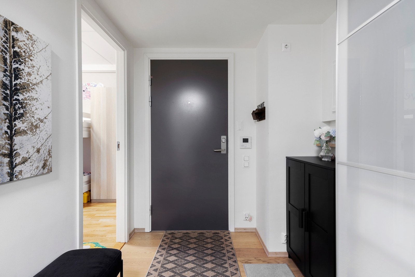 Leiligheten har en lys og innbydende entré med calling-annlegg til hoveddøren Galleribilde