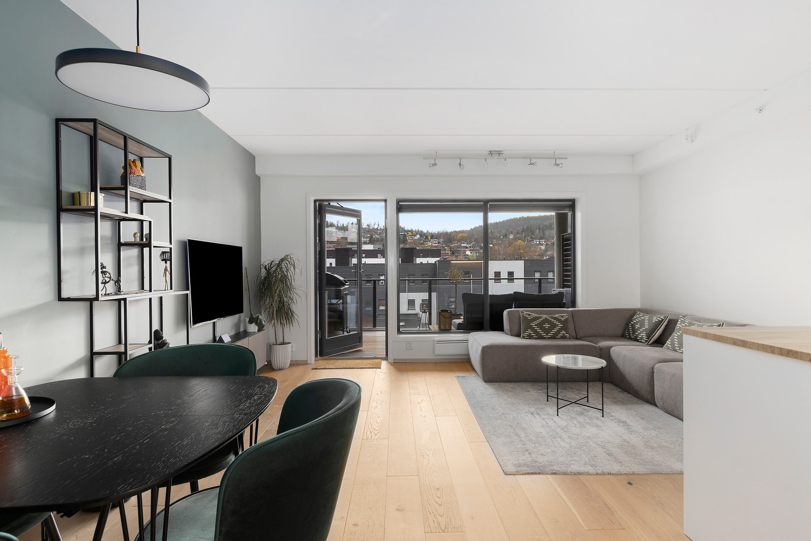 Leiligheten har en åpen stue-/kjøkkenløsning med store vindusflater som gir rikelig med naturlig lysinnslipp Galleribilde