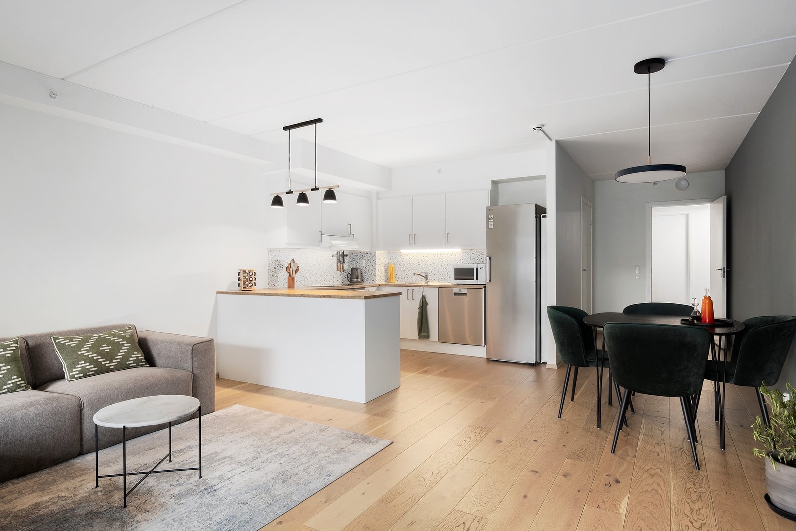 Videre inn i stuen beveger vi oss mot spisestue og kjøkken Galleribilde