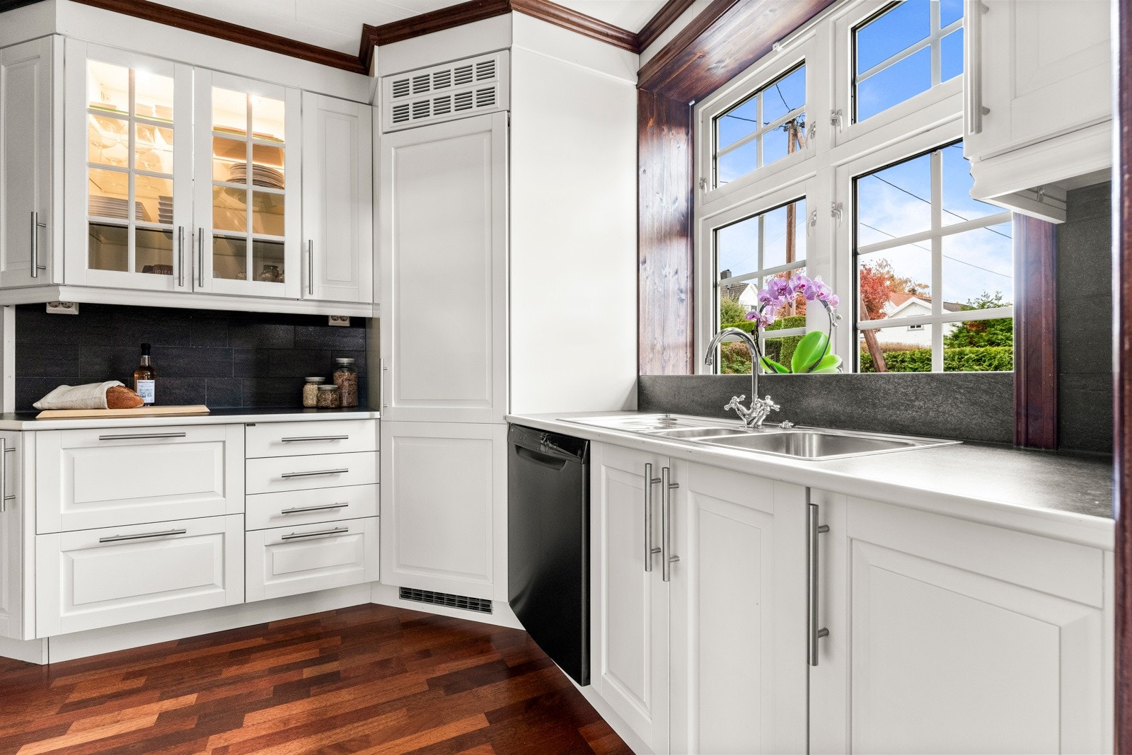 Fra kjøkkenet har man stort vindu og utsikt mot grøntarealer Galleribilde