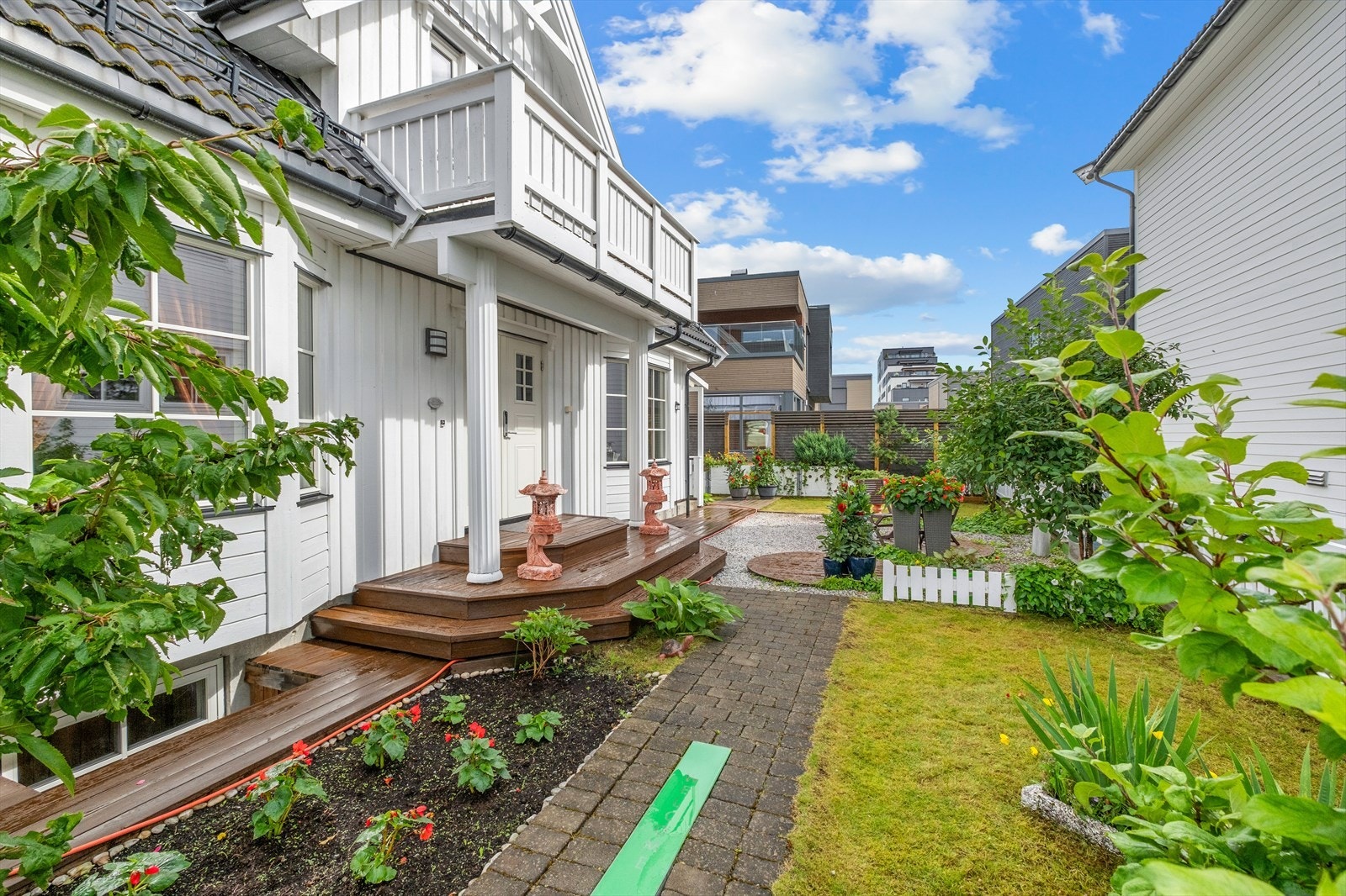 Her får man flere uteområder som hage med frodige blomster, platting, sittegrupper og to takterrasser. Galleribilde