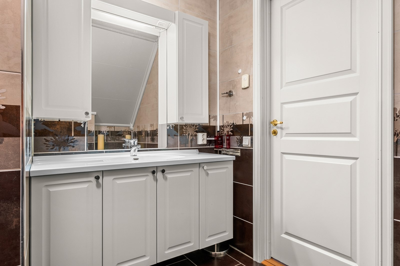 Videre er badet utstyrt med servantskap, veggmontert wc og mekanisk avtrekk. Galleribilde