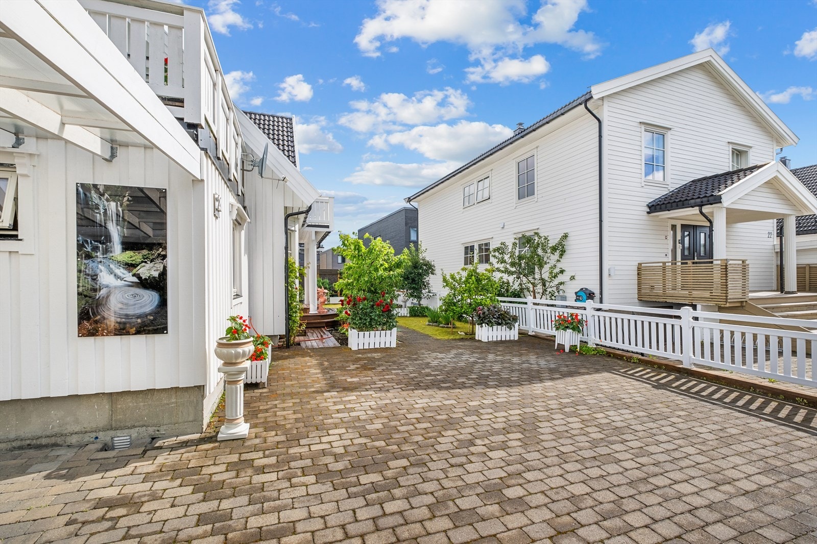 Tomten måler 411m² og byr på flere uteplasser, opparbeidet gårdsplass med brostein, carport og flere oppstillingsplasser på tomt. Galleribilde