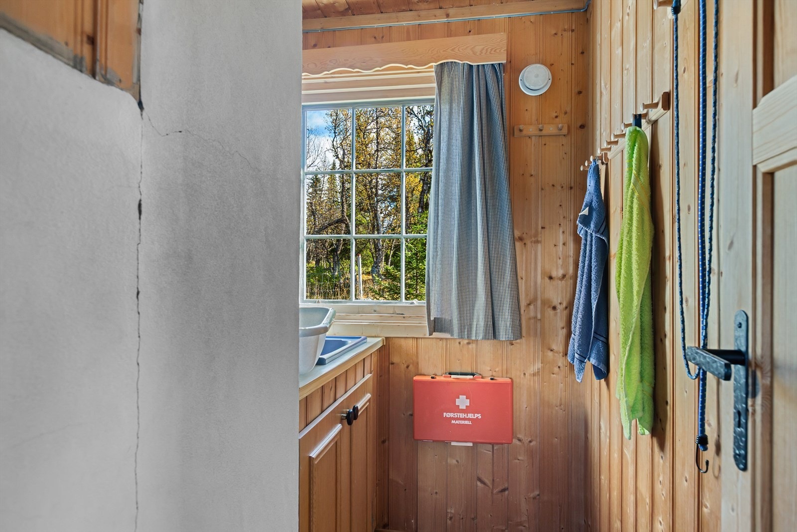 Sanitærrommet er enkelt, med gulvbelegg og panelte vegger. Her finner du servant med underskap og speil. Galleribilde