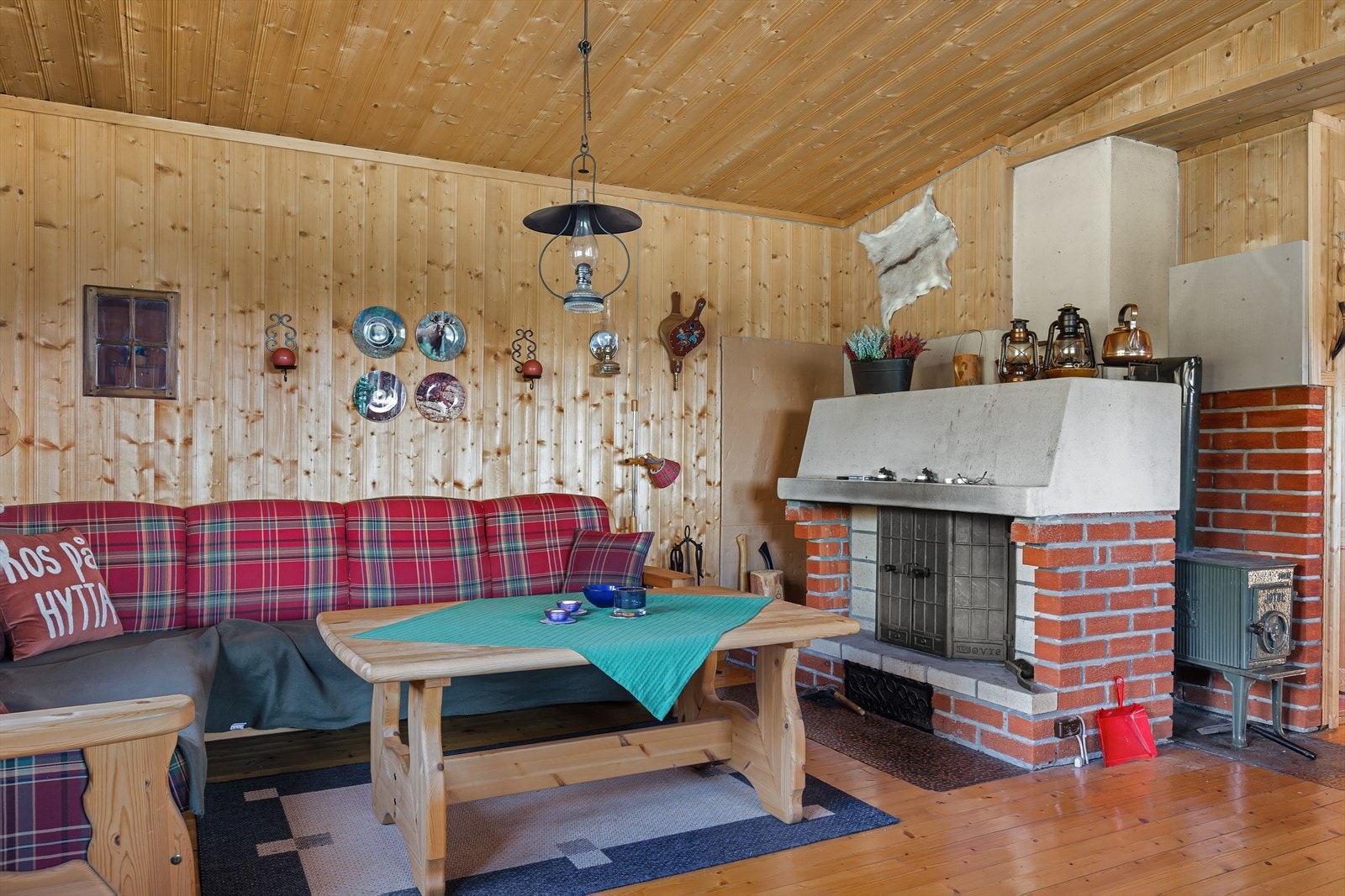 En plassmurt peis med innsats, forblendet med teglstein, gir et fint innsyn til flammene, og en vedovn ved siden av peisen gir ekstra varme på kalde dager. Galleribilde