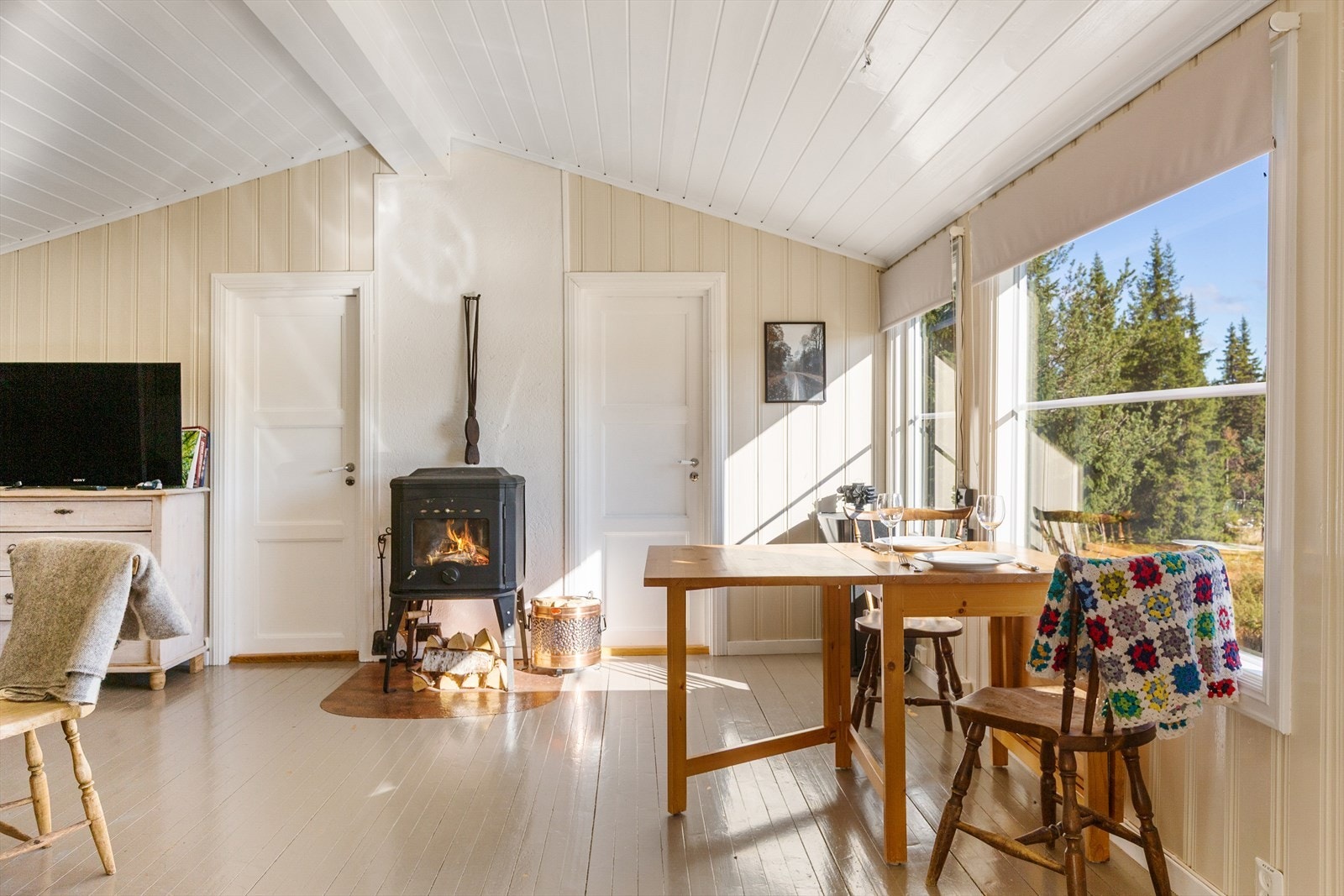 En nyere vedovn med glassdør sørger for lun varme og stemningsfullt innsyn til flammene. Galleribilde