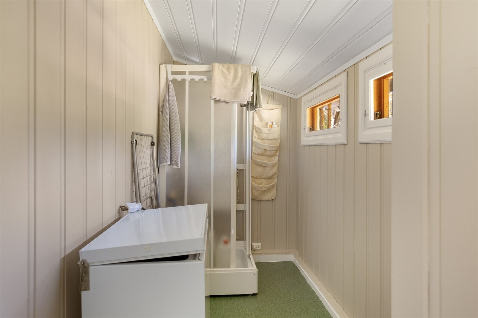 Rommet er utstyrt med dusjkabinett som pumper vann fra kanne, og benyttes også til lagring. Galleribilde