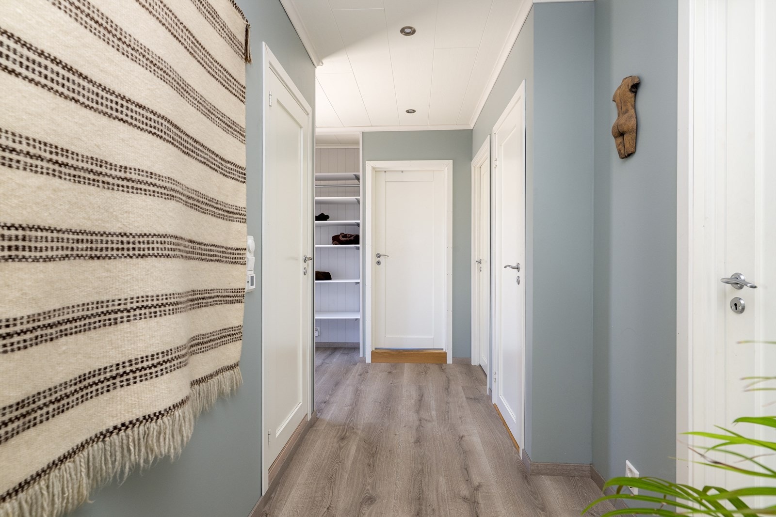 Gangen har god plass til sko- og ytterklær på knagger og hyller. Fra gangen er det adkomst til soverom, bad og vaskerom, samt til underetasjen. Galleribilde