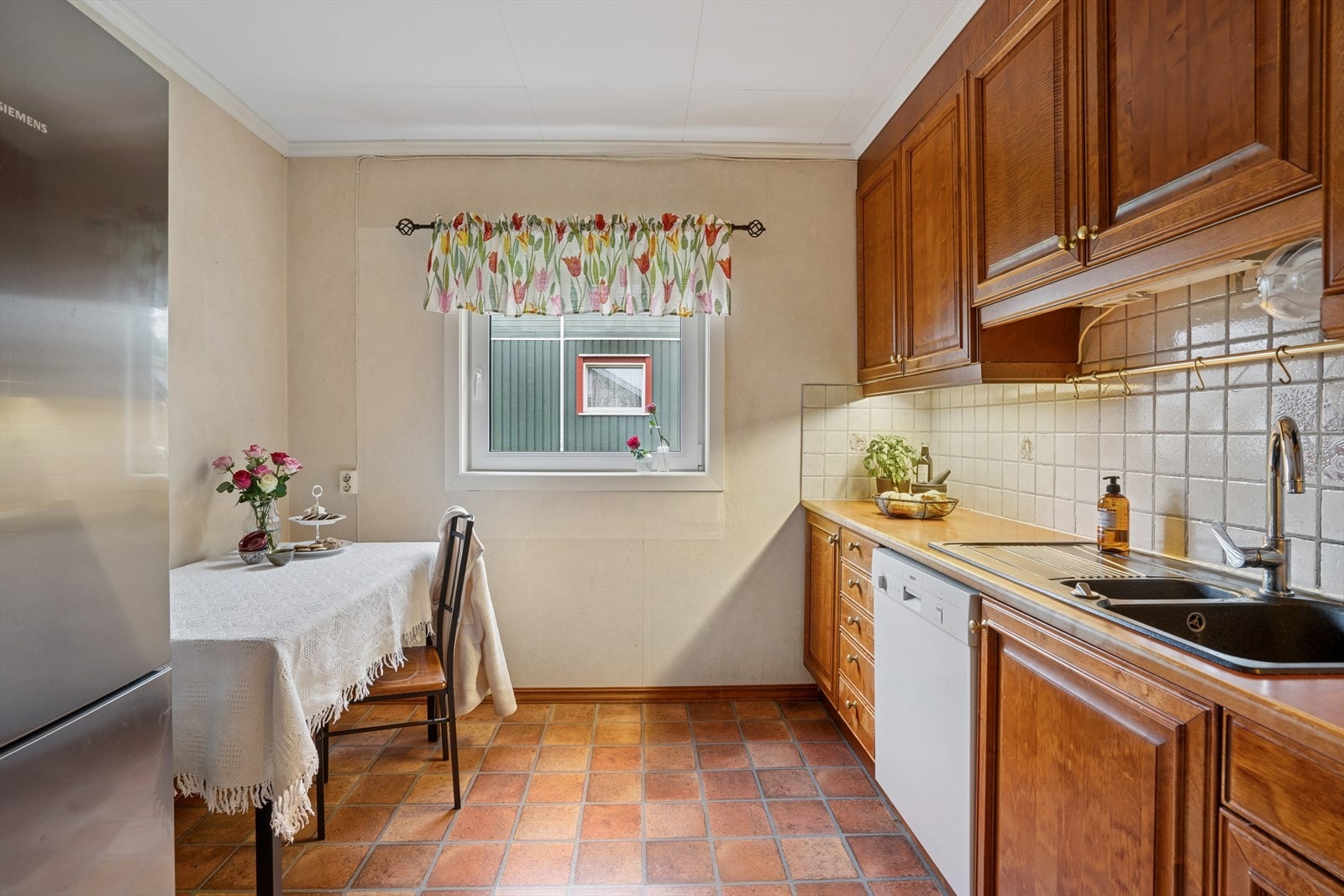 Kjøkkenet har mørke profilerte fronter og benkeplate av laminat med oppvaskkum. Galleribilde