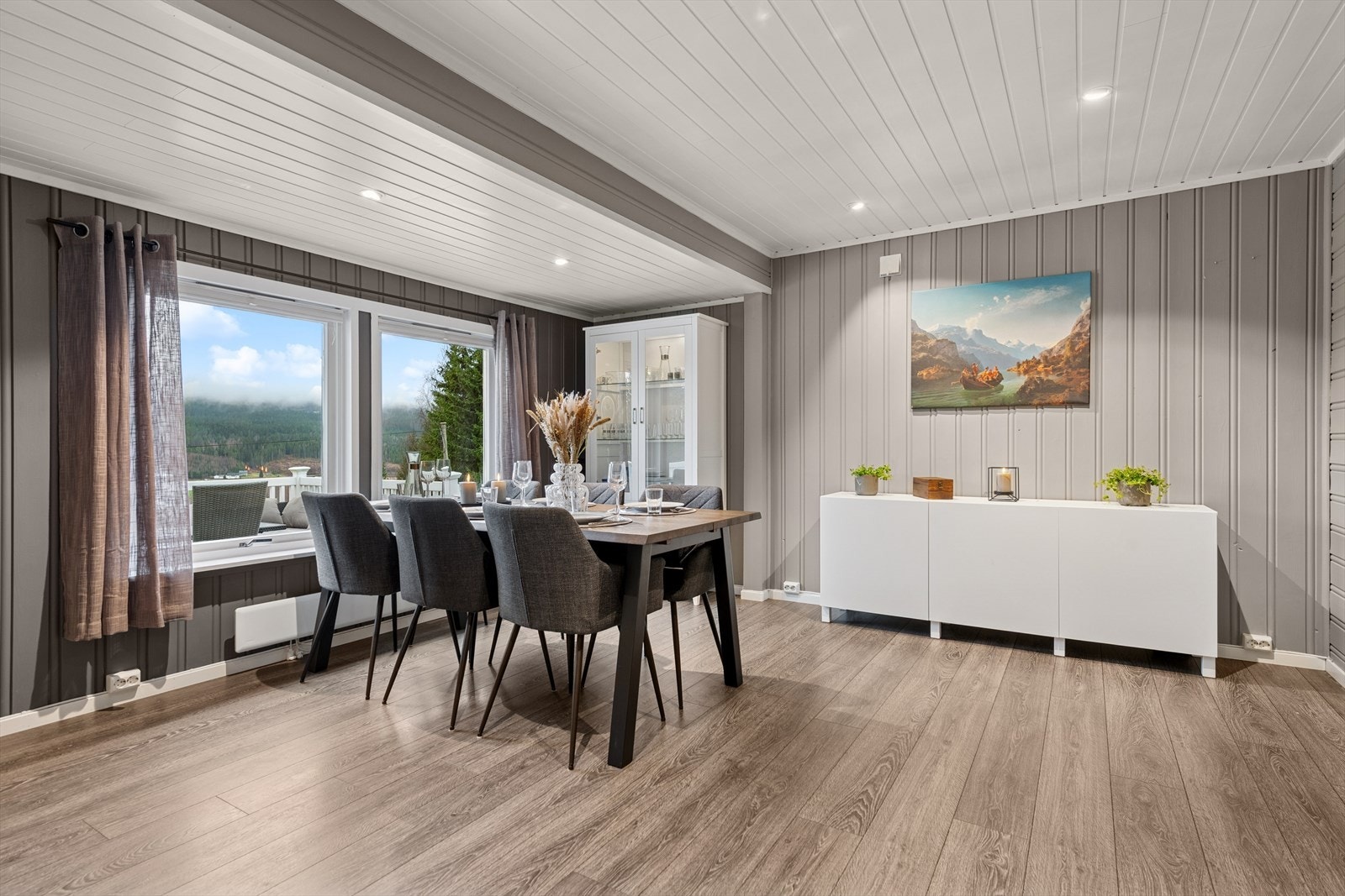 Store vinduer gir spisestuen et flott utsyn mot naturen utenfor. Galleribilde