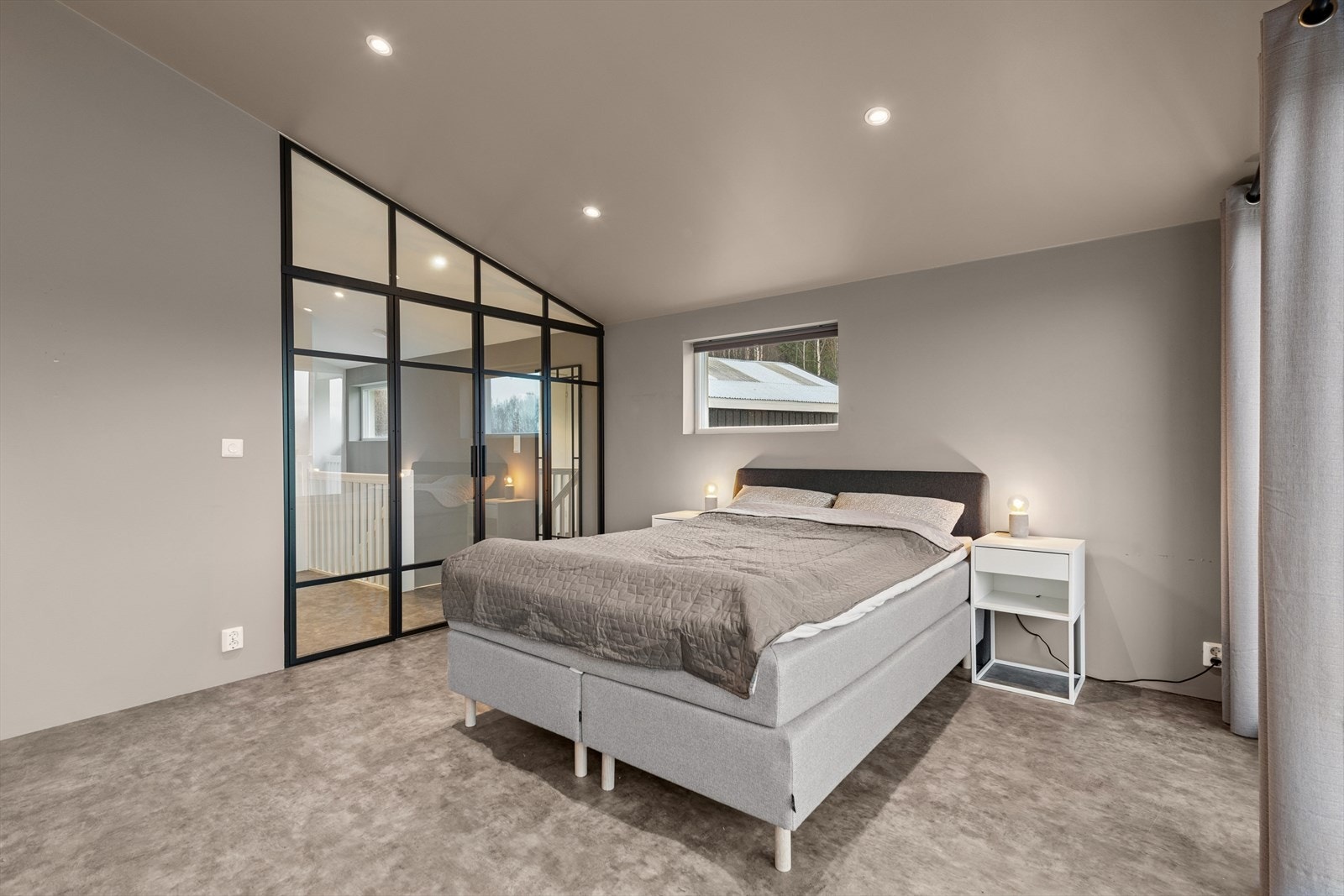 Glassvegg med dør gir en moderne romdeling i soverommet. Galleribilde