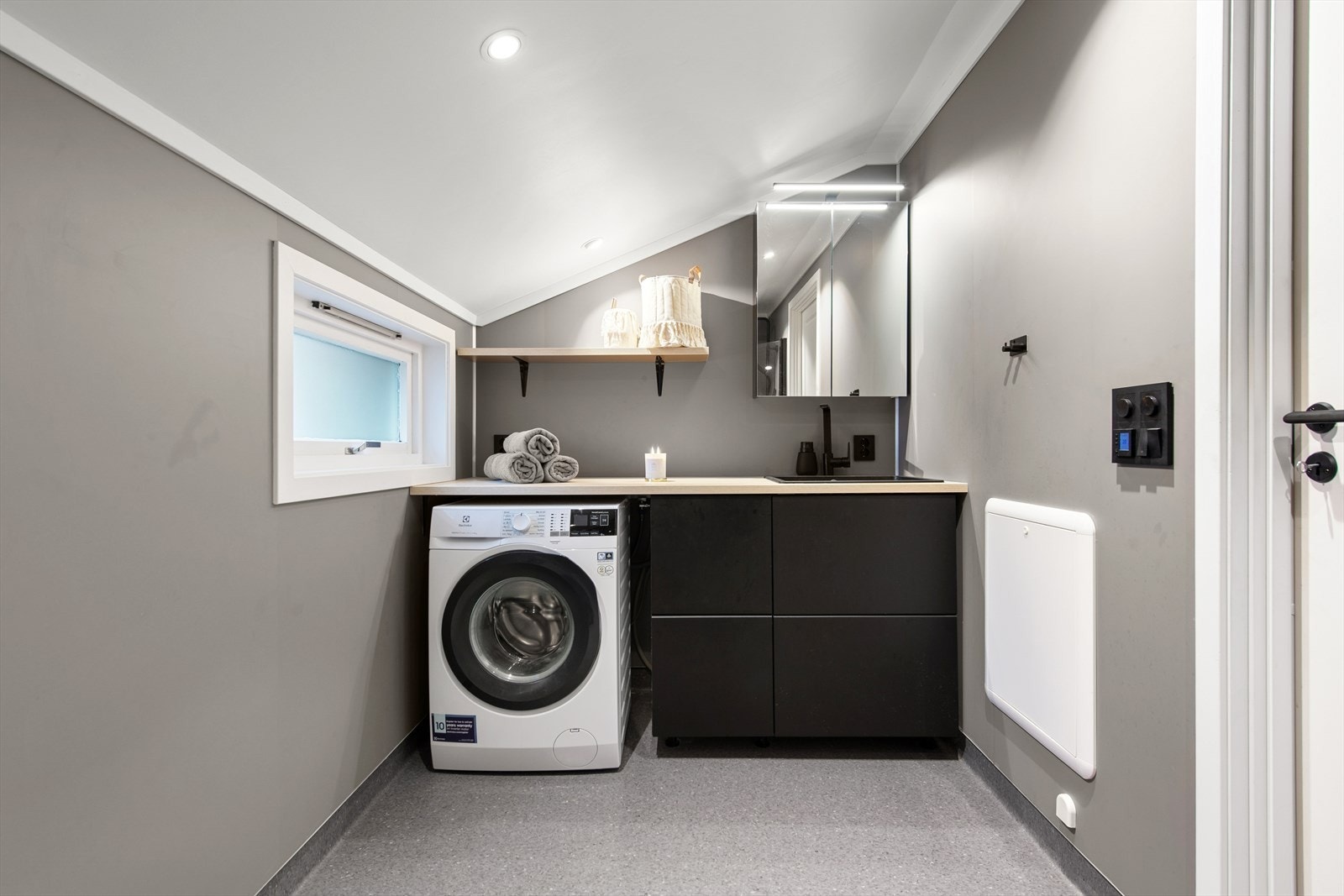 Badet er utstyrt med toalett, dusjhjørne, baderomsinnredning og opplegg til vaskemaskin. Galleribilde