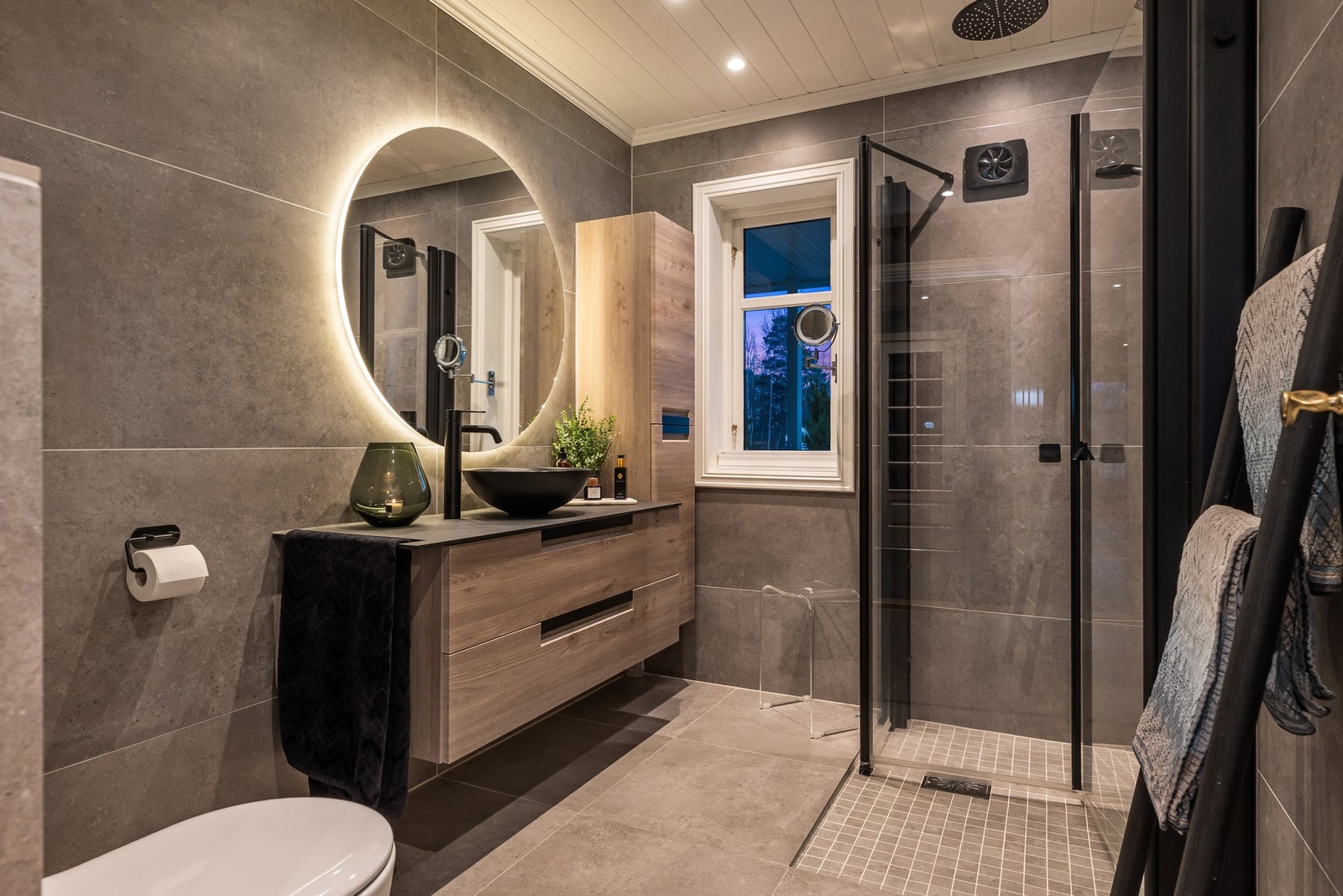 I boligens hovedetasje ligger et smakfult og moderne bad med flislagte overflater og downlights. Galleribilde