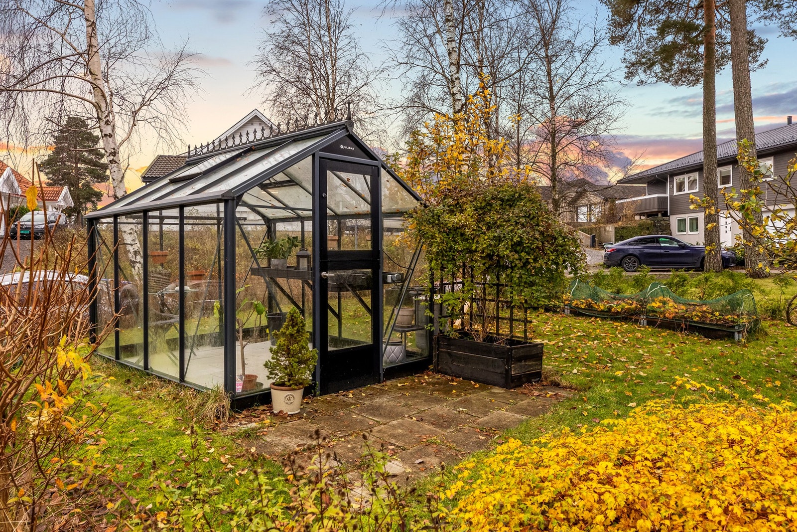 Uteområdet er pent opparbeidet med plen, beplantning og et hyggelig drivhus fra 2019. Galleribilde