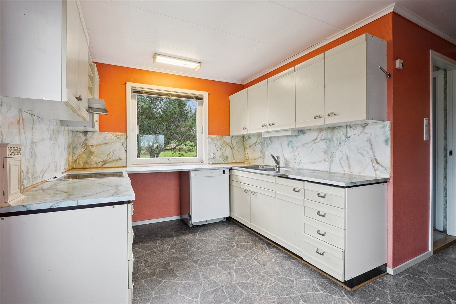 Kjøkkeninnredningen har slette fronter med pyntelister, laminerte benkeplater, vask i rustfritt stål og opplegg for oppvaskmaskin. Galleribilde