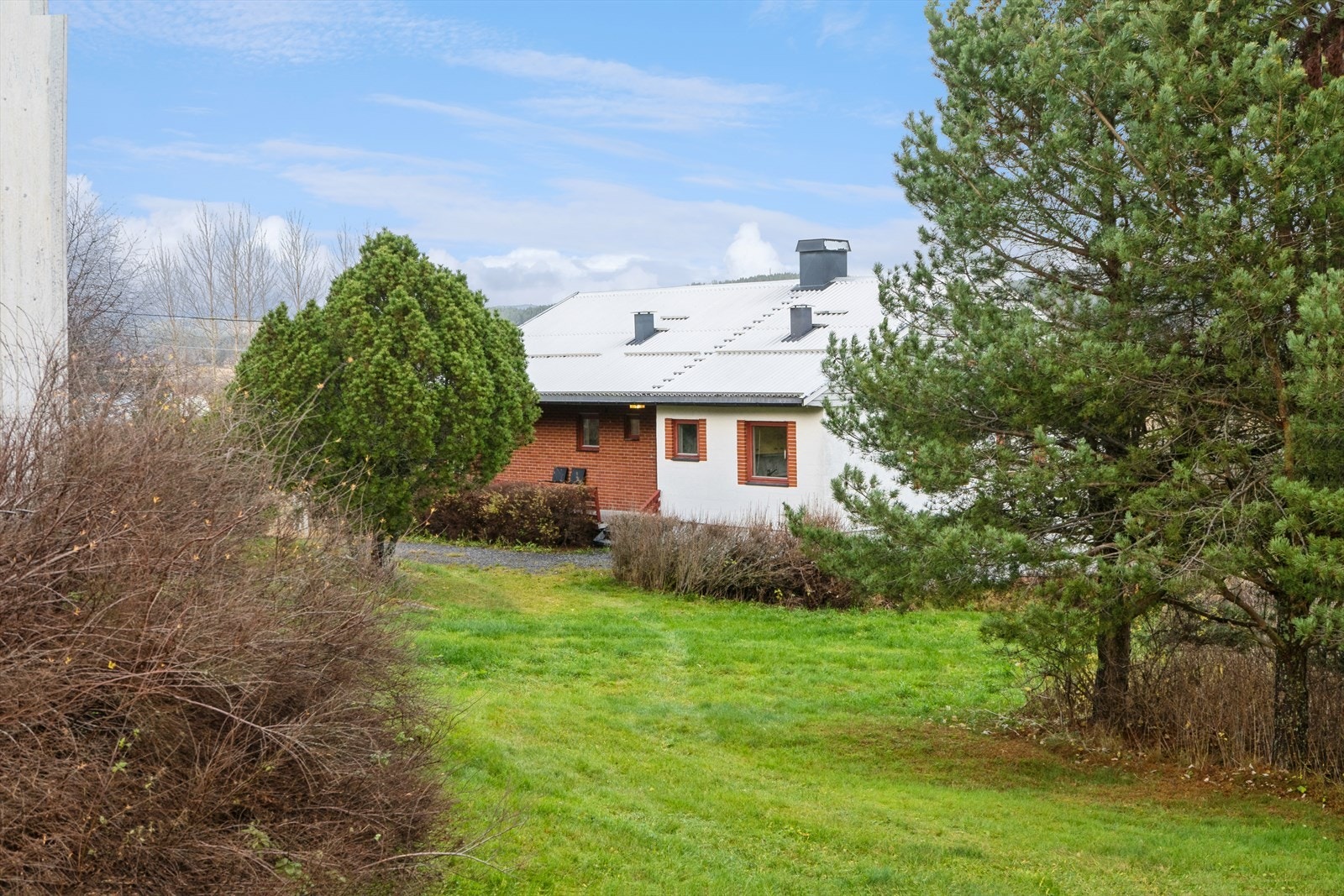 Tomten ved boligen er opparbeidet med plen, prydbusker og trær. Galleribilde