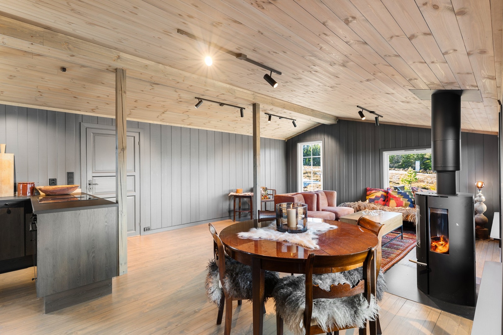 Røstet tak og store vindusflater slipper daglyset og utsikten inn Galleribilde